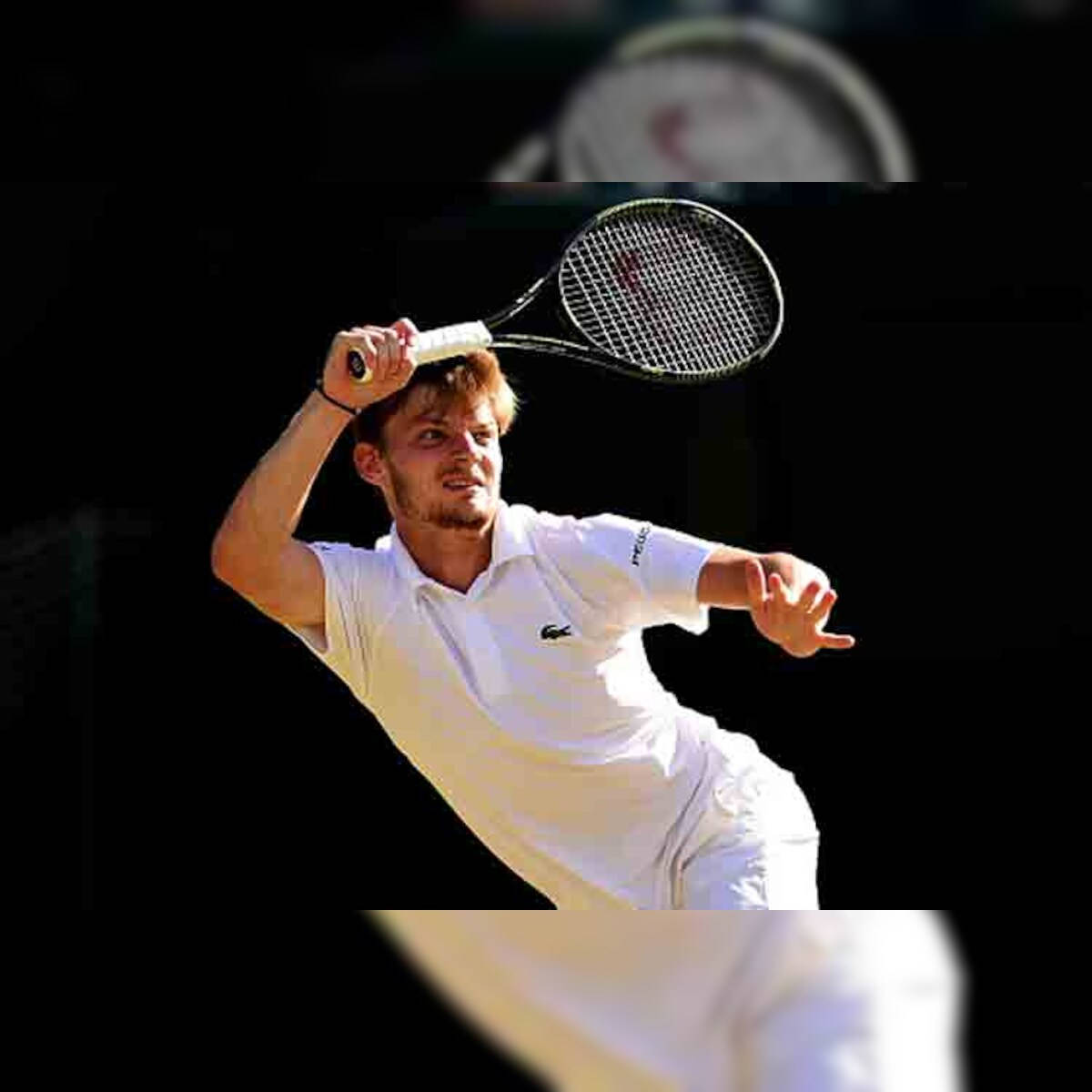 Tennis 桌布 壁紙 — 一名身穿白色服裝的男性網球選手在深色背景下執行強力過頭扣殺。