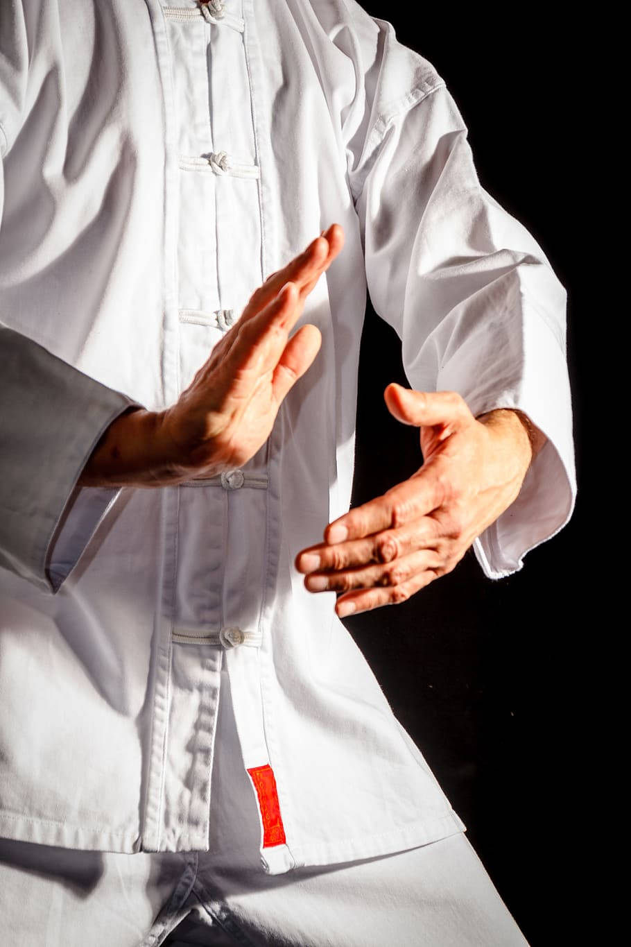martial arts 桌布 壁紙 — 一名身穿白色武術制服的人在純黑背景前做出優雅的手勢。