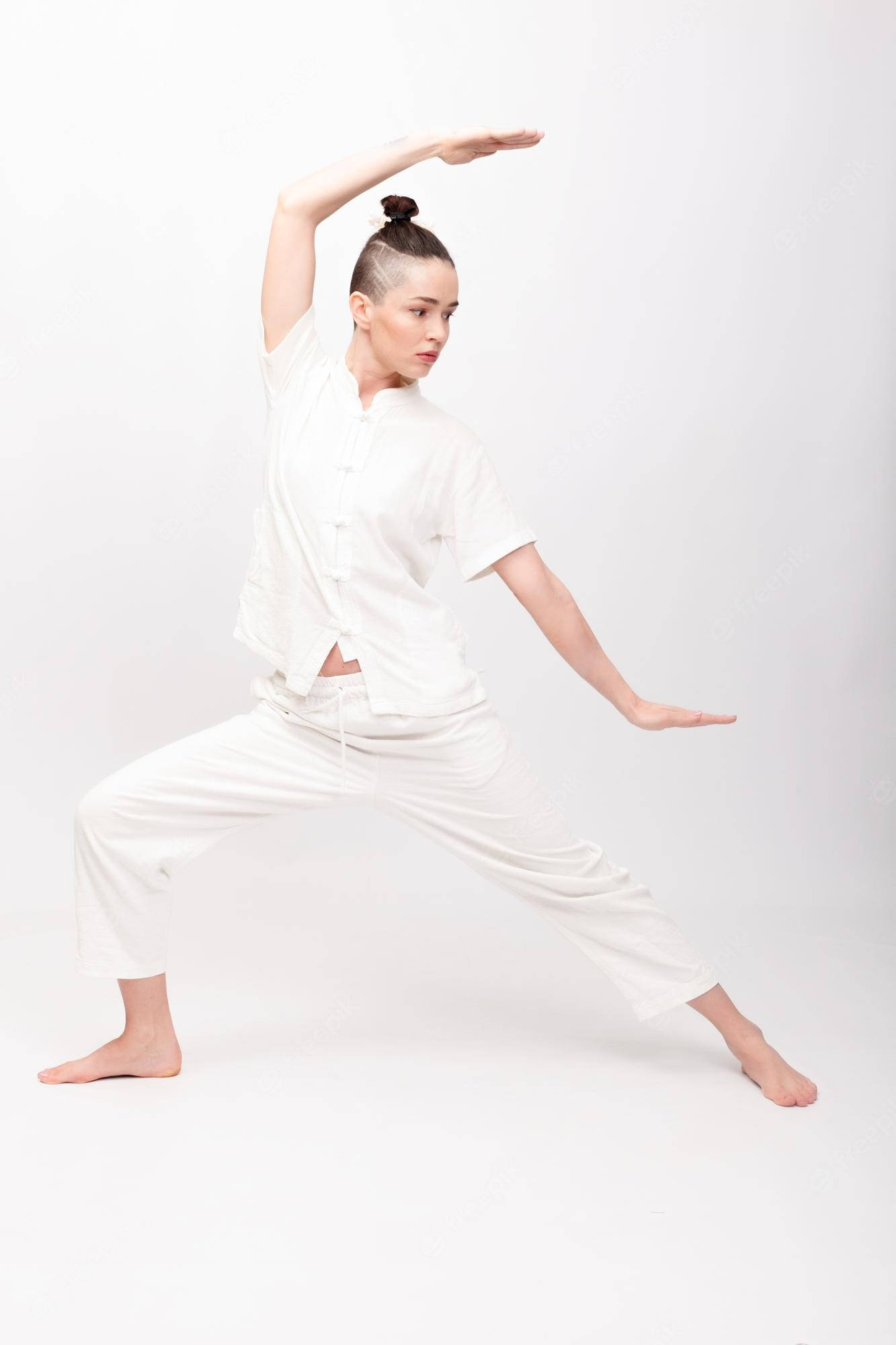 martial arts 桌布 壁紙 — 一名身穿白色武術服裝的女性，在無縫白色攝影棚背景前擺出平衡姿勢。