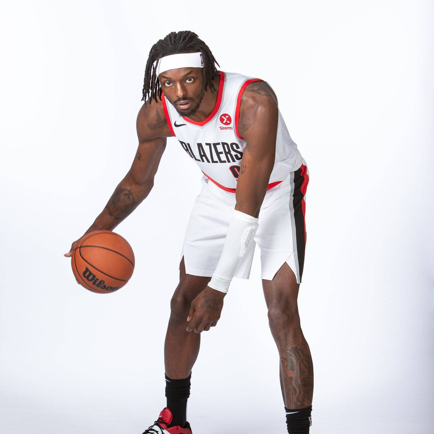 NBA 桌布 壁紙 — 一名身穿白色波特蘭拓荒者隊球衣的籃球運動員，在純白色背景前運著橙色的Wilson籃球。