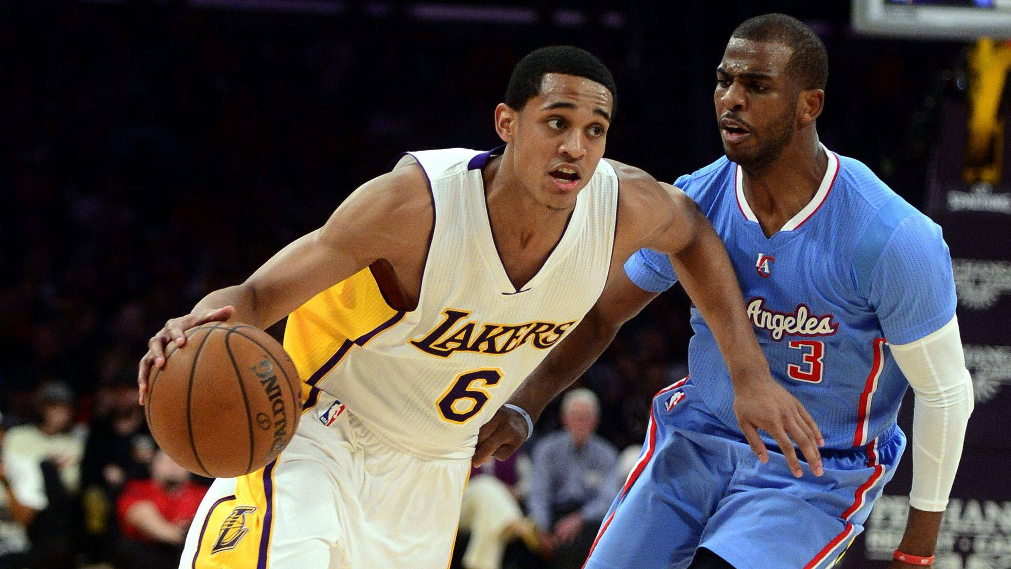 Jordan Clarkson 桌布 壁紙 — 一名身穿白色湖人球衣的籃球運動員在比賽中運球，同時被一名身穿藍色快艇球衣的對手緊密防守。