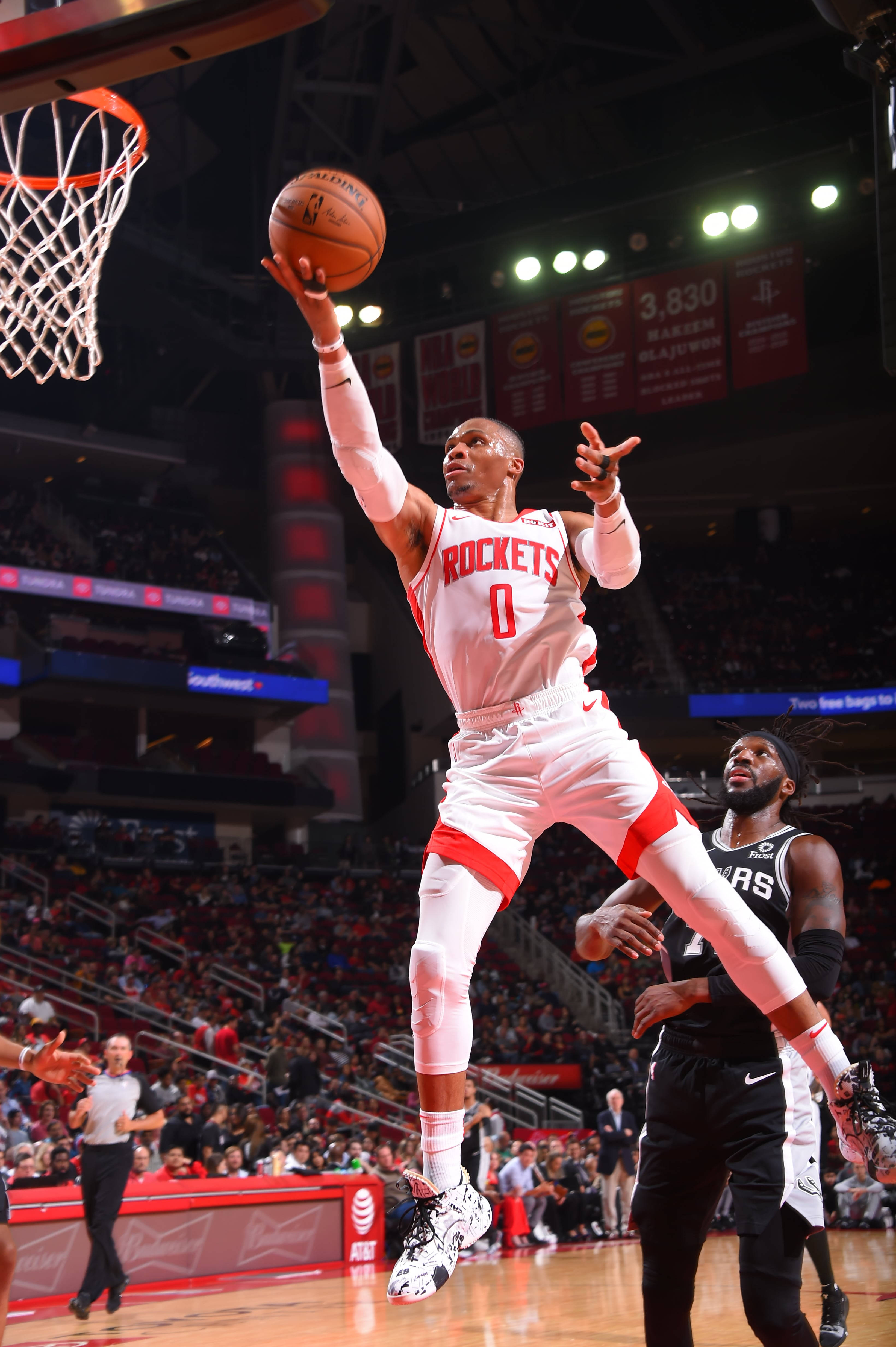 Westbrook 桌布 壁紙 — 一名身穿白色火箭隊球衣的籃球運動員高高躍起灌籃，防守球員在擠滿觀眾的場館下方觀看。