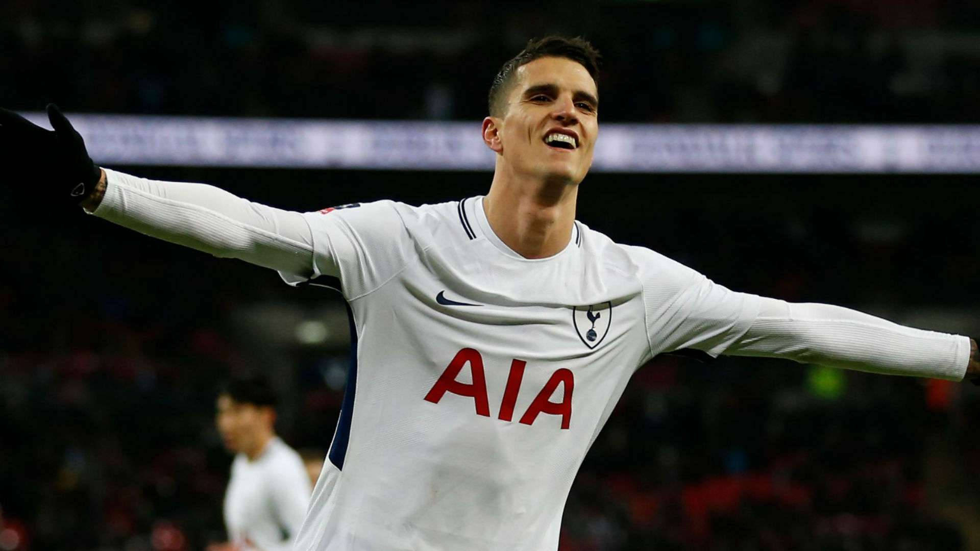 erik lamela 桌布 壁紙 — 一名身穿白色熱刺球衣的足球員在球場燈光下張開雙臂慶祝。