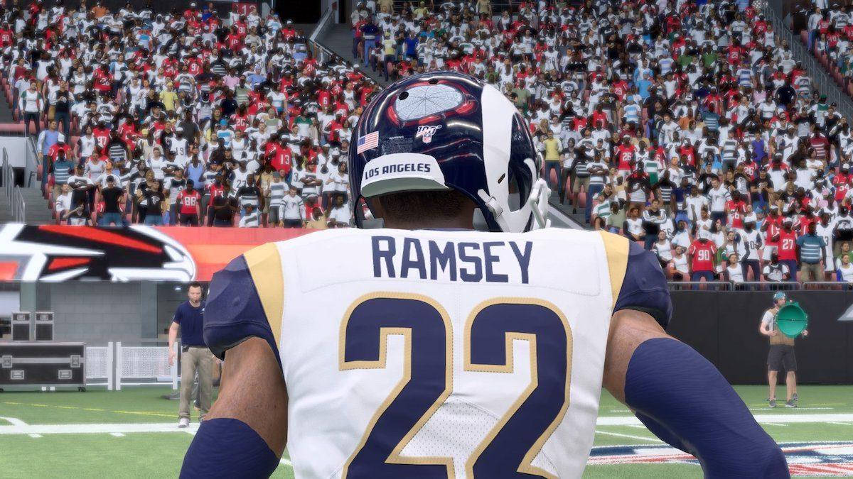 Ramsey 桌布 壁紙 — 一名身穿白色球衣、印有Ramsey名字和22號的足球員站在球場上，面對著擠滿觀眾的體育場。