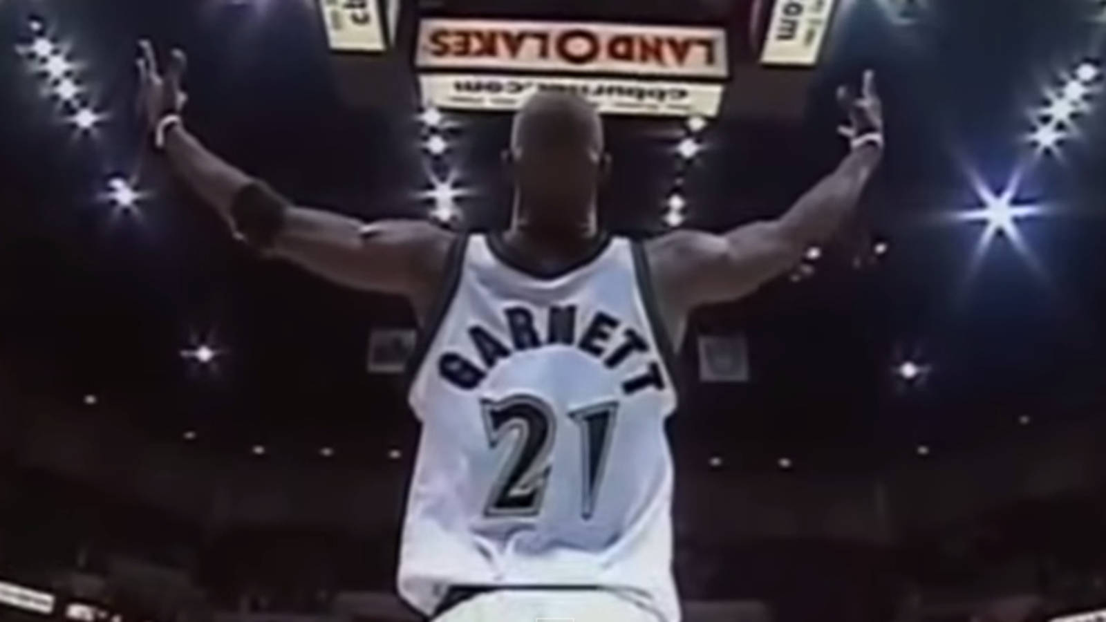 Kevin Garnett 桌布 壁紙 — 一名身穿白色球衣、印有名字和21號的籃球運動員，在明亮的場館燈光下高舉雙臂慶祝勝利。