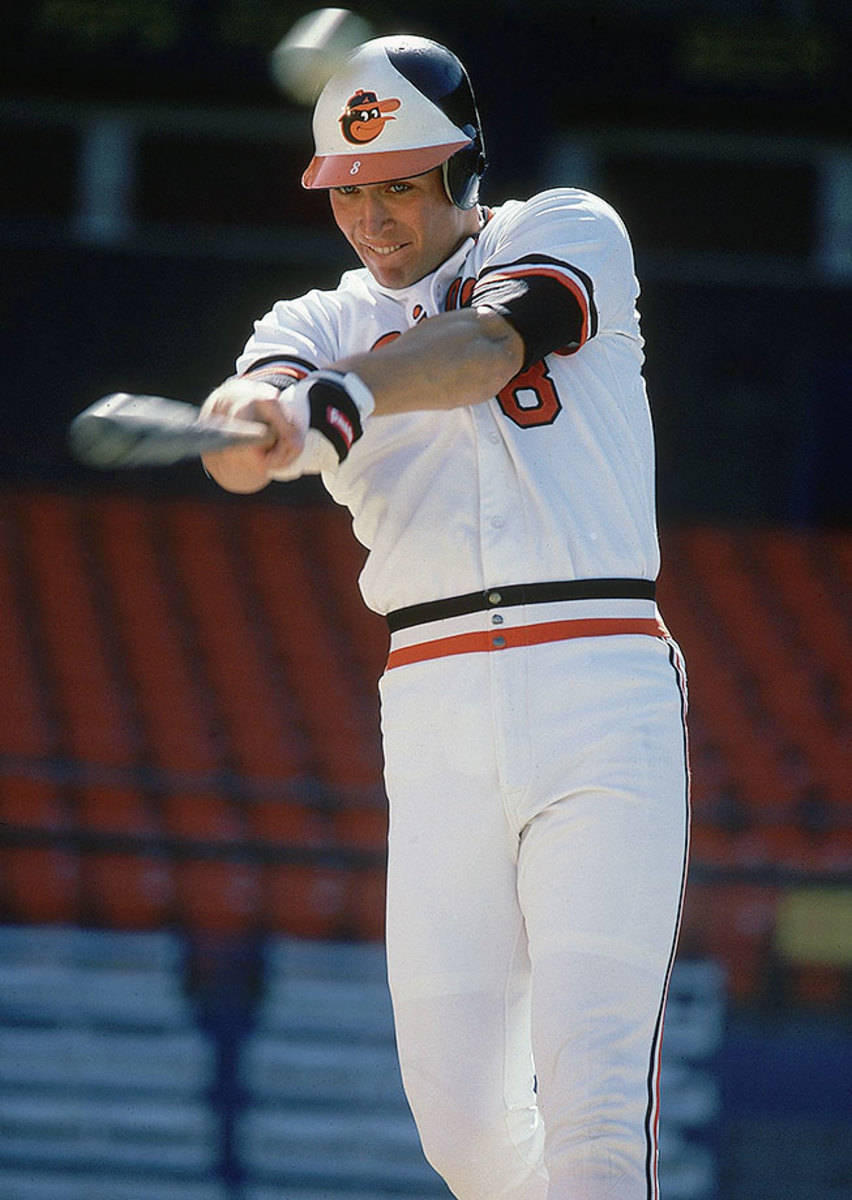 cal ripken jr 桌布 壁紙 — 一名身穿白色球衣、帶有橙色和黑色點綴的棒球運動員，在揮棒中途專注地揮動球棒。