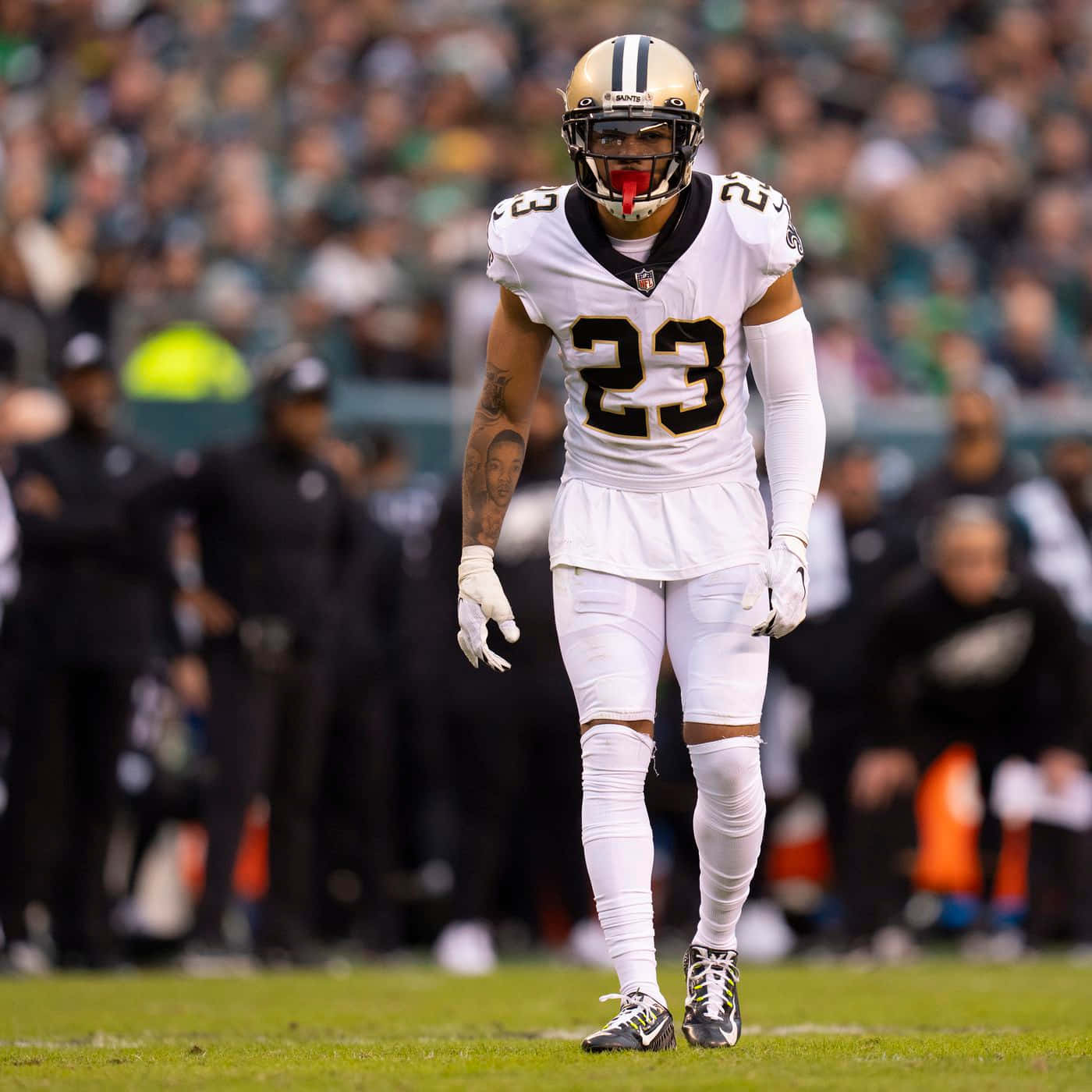New Orleans Saints 桌布 壁紙 — 一名身穿白色球衣、背號23的紐奧良聖徒隊美式足球員在比賽期間走進球場，背景有觀眾。