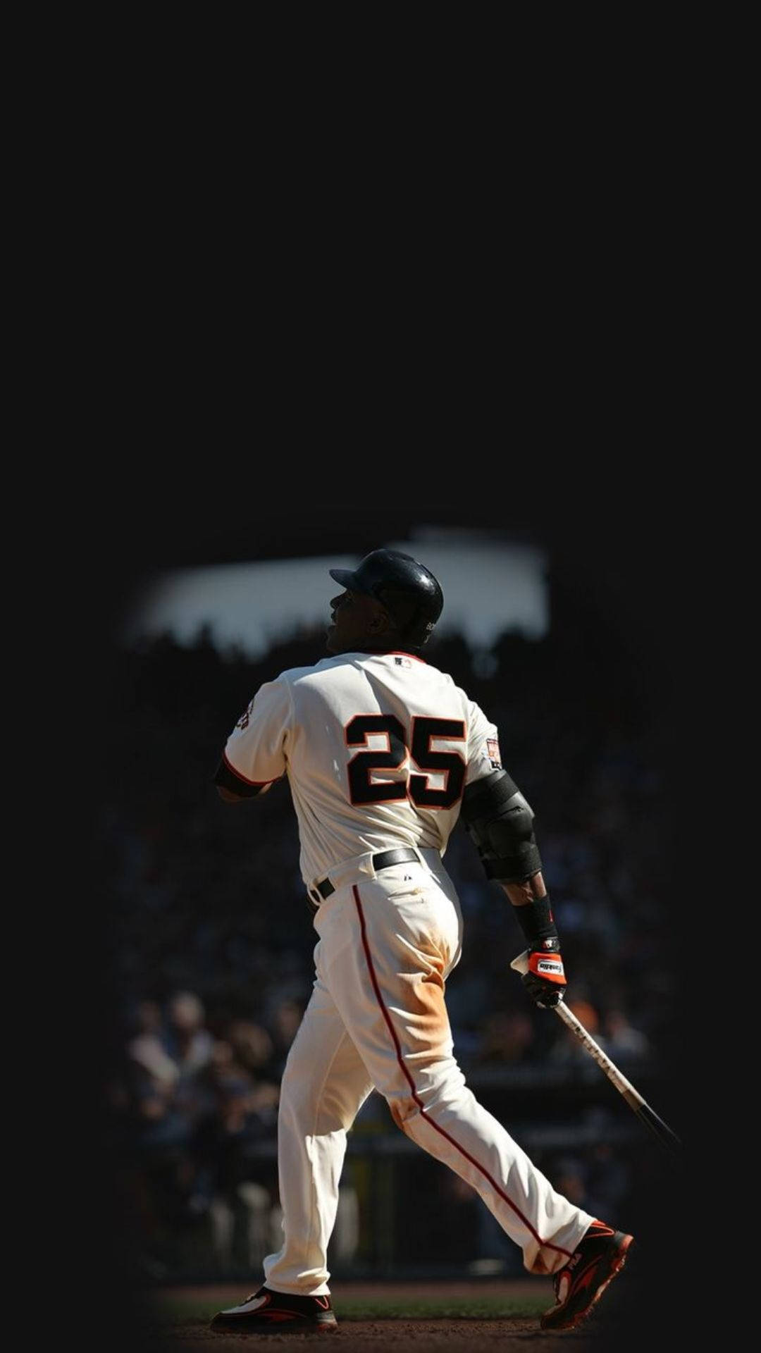 Giants 桌布 壁紙 — 一名身穿白色球衣、背號25的棒球選手，在明亮的球場燈光下，對著黑暗的球場背景揮棒。