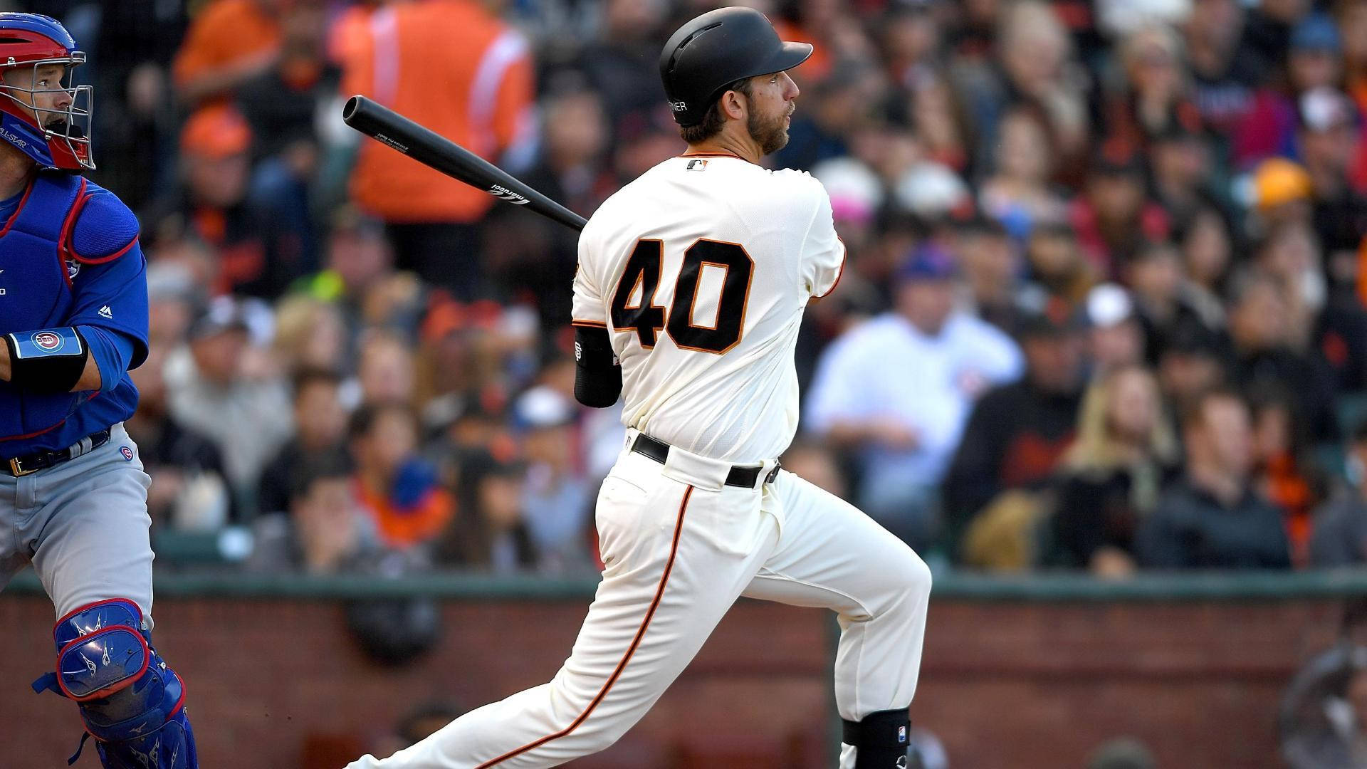 madison bumgarner 桌布 壁紙 — 一名身穿白色球衣、背號40的棒球打擊手正在揮棒，而一名身穿藍色裝備的捕手蹲在他身後。