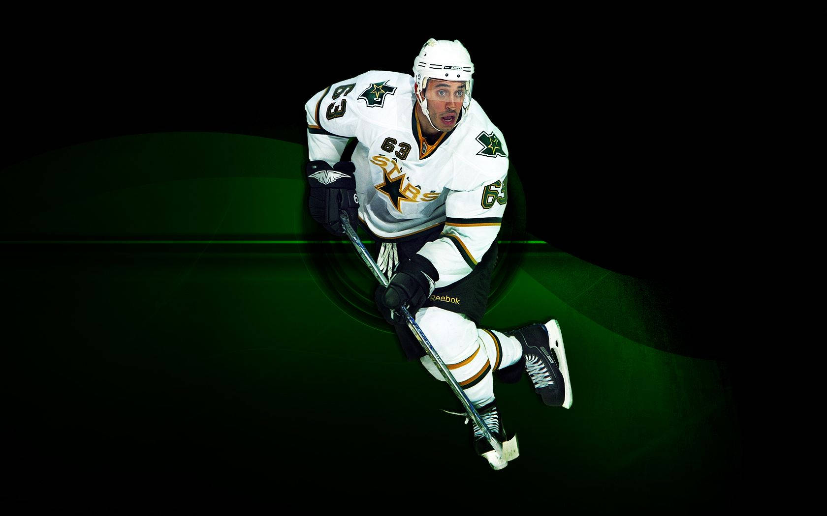 Dallas Stars 桌布 壁紙 — 一名身穿白色球衣、背號63的冰球運動員，在發光的綠色抽象背景前動態地蹲下。