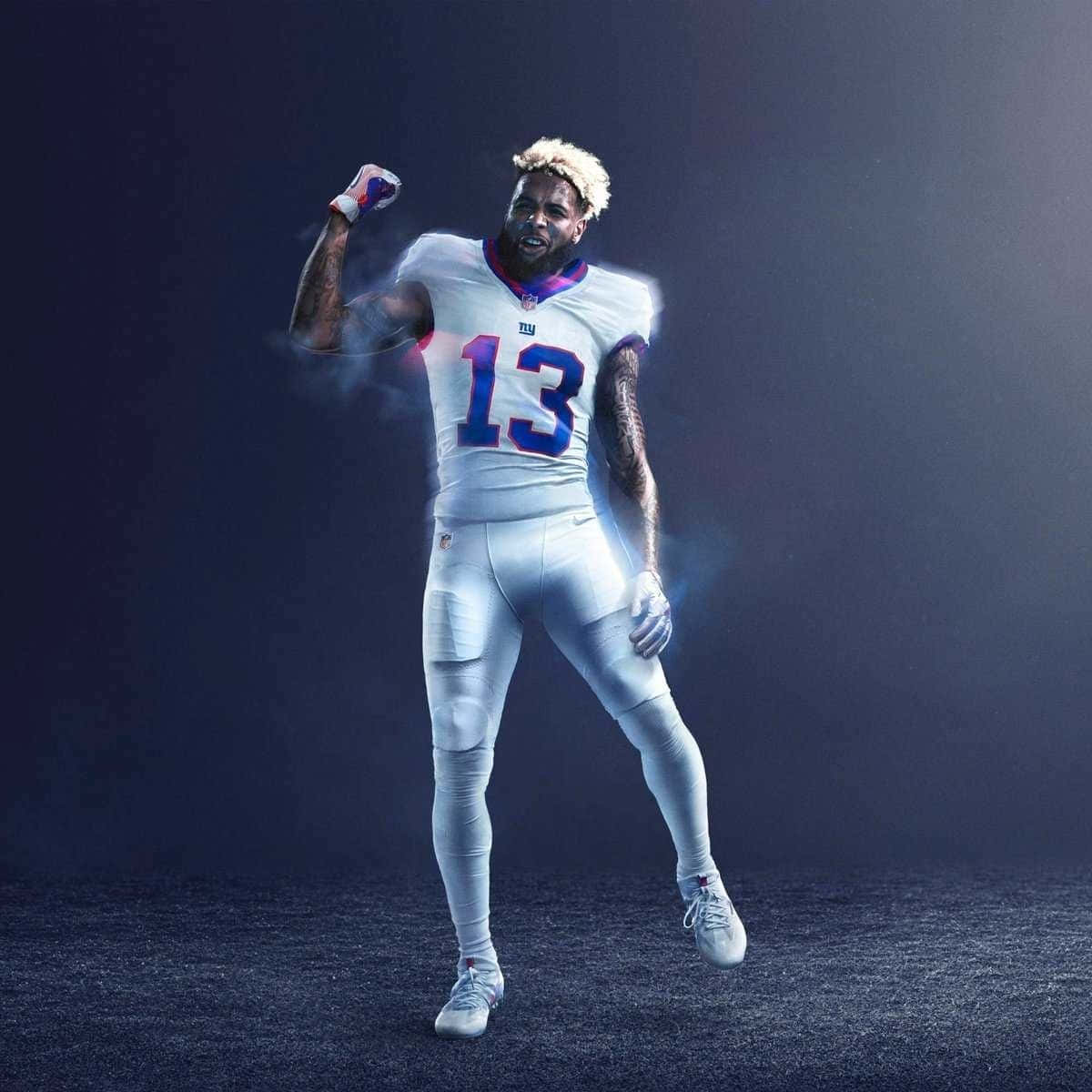 Obj 桌布 壁紙 — 一名身穿白色球衣、號碼13的足球運動員在黑暗煙霧背景下高舉拳頭慶祝勝利。