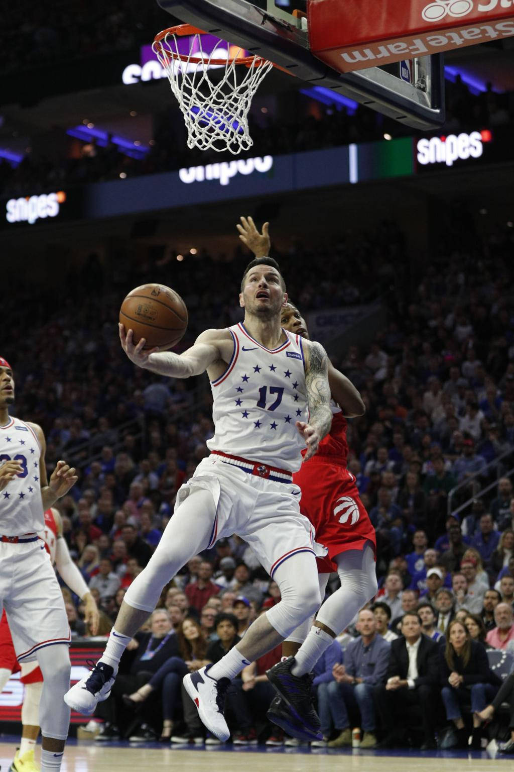 Jj Redick 桌布 壁紙 — 一名身穿白色球衣、號碼17的籃球運動員在擠滿觀眾的場館比賽中，跳向籃框準備灌籃，防守球員正逼近。