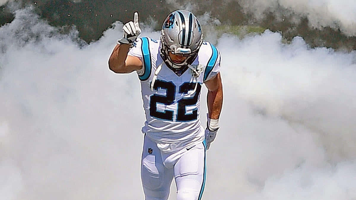 Christian Mccaffrey 桌布 壁紙 — 一名身穿白色球衣、號碼22的卡羅萊納黑豹美式足球員從球場上的煙霧中出現。
