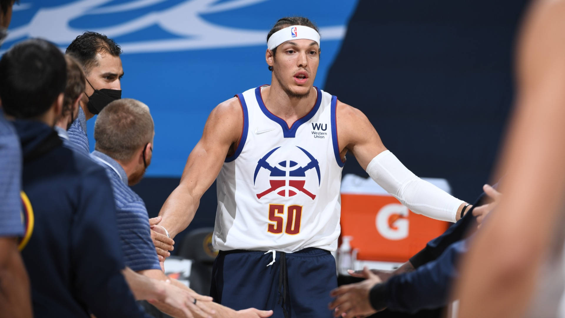 aaron gordon 桌布 壁紙 — 一名身穿白色球衣、號碼50的籃球運動員在比賽中與隊友握手。