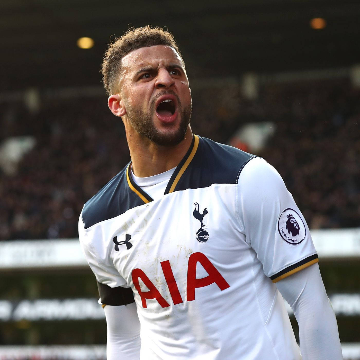 Kyle Walker 桌布 壁紙 — 一名身穿白色球衣的托特納姆熱刺足球員在日間比賽中，於座無虛席的球場上激情咆哮。