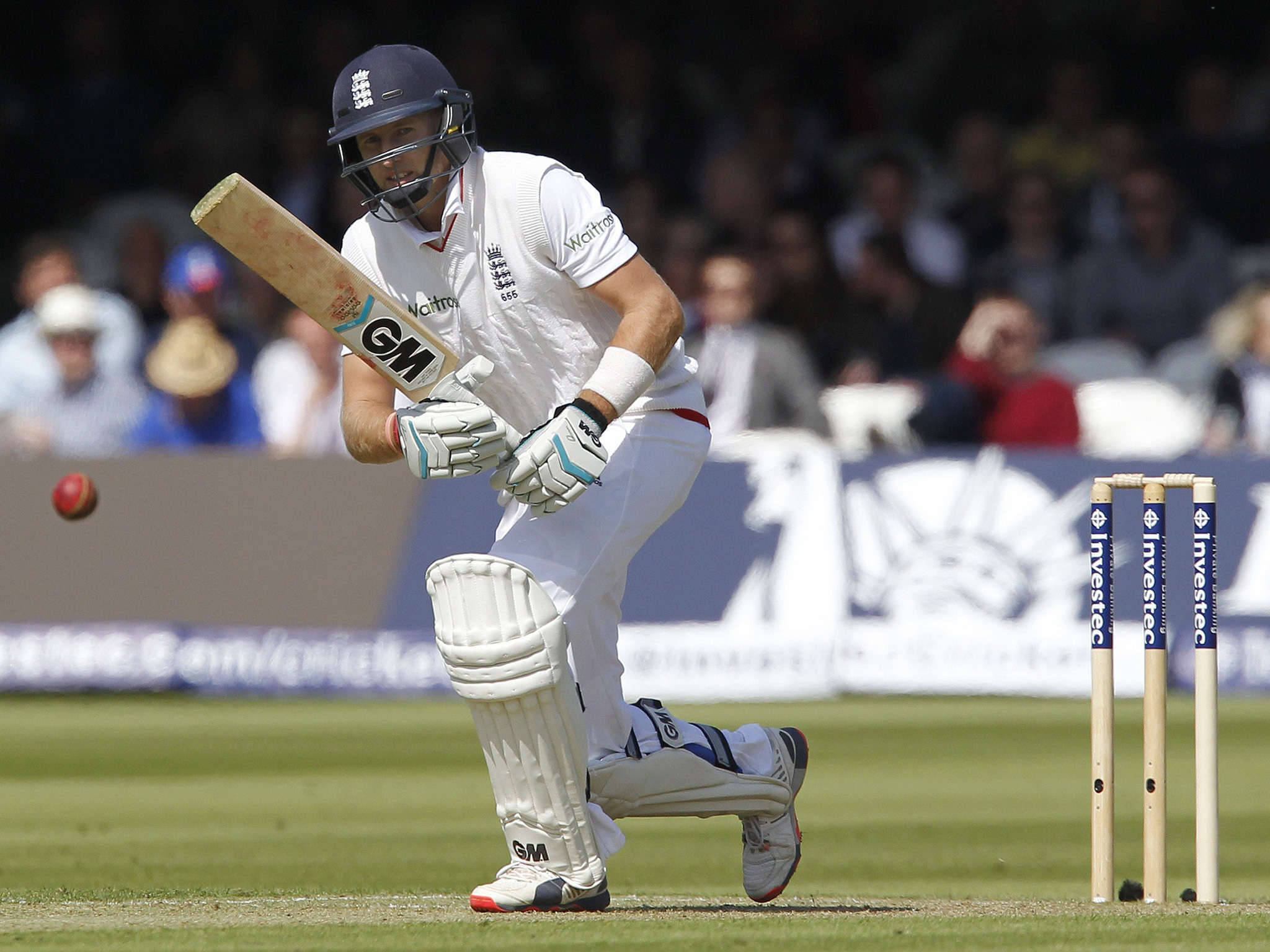 England Cricket 桌布 壁紙 — 一名身穿白色球衣的板球擊球手在綠色場地上進行日間比賽時揮動球棒擊打紅球。