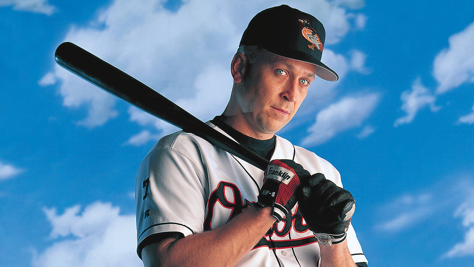 cal ripken jr 桌布 壁紙 — 一名身穿白色球衣的棒球運動員，在藍天白雲下揮棒。