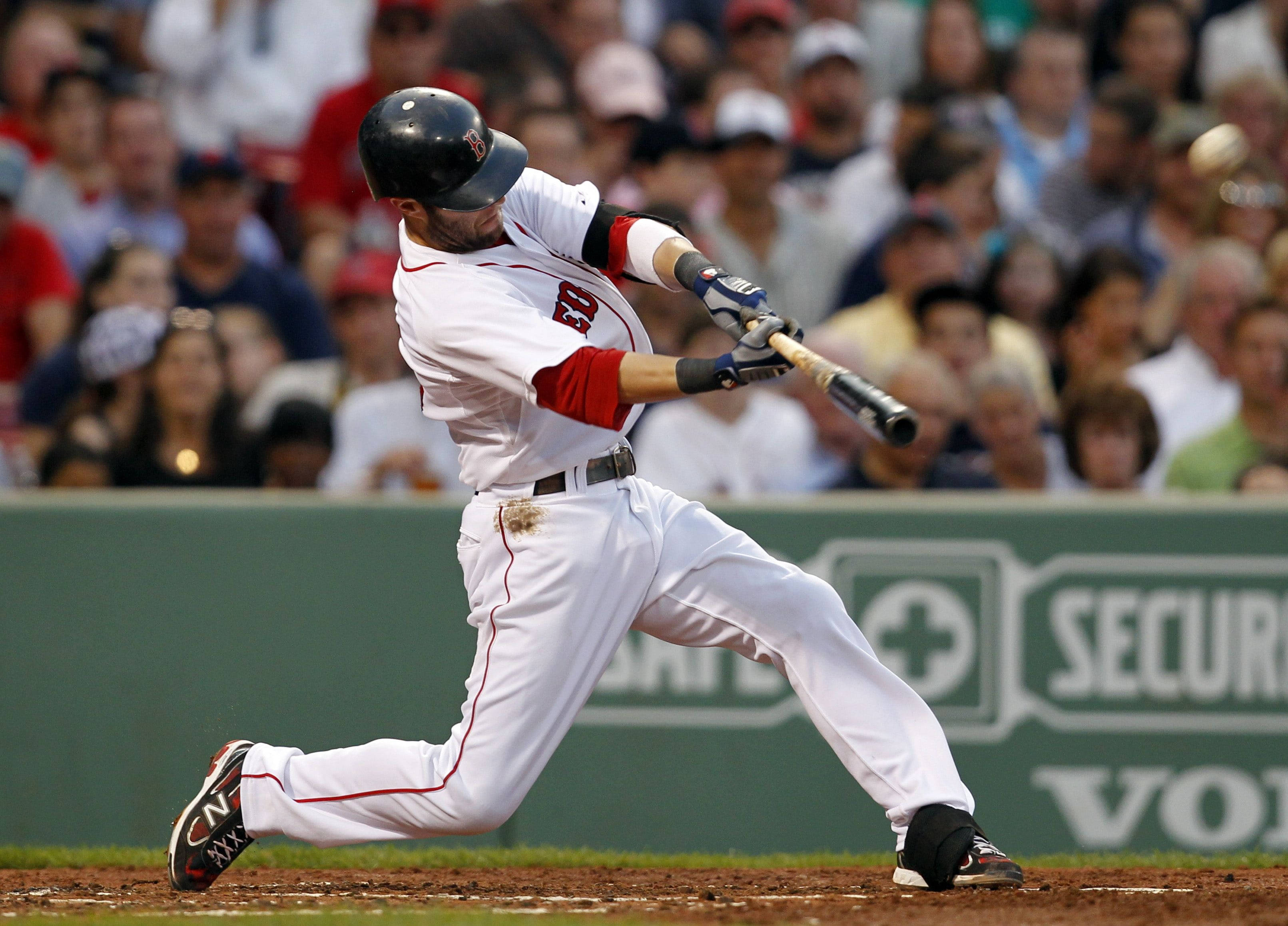Boston Red Sox 桌布 壁紙 — 一名身穿白色球衣的棒球選手在日間比賽中，在模糊的人群前專注地揮棒。