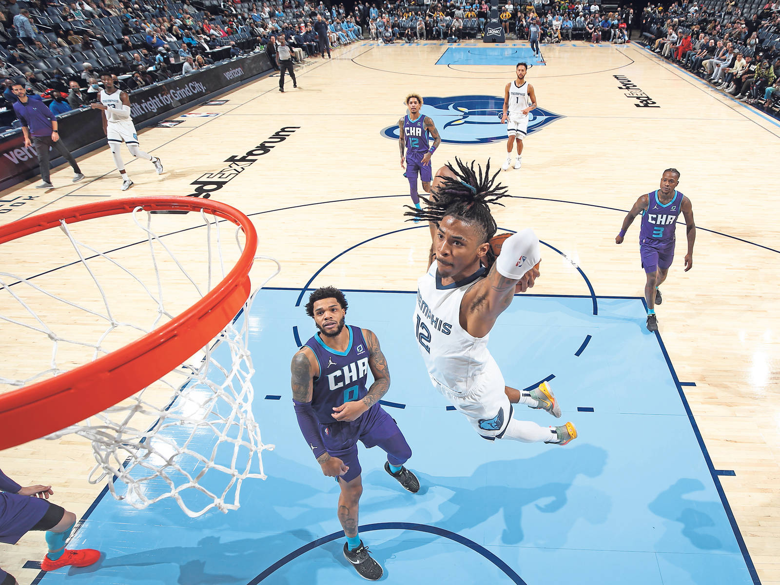 籃球運動員在半空中隔著防守球員灌籃。 — Ja Morant 動圖 壁紙