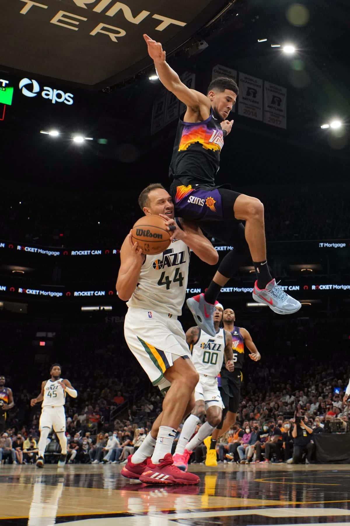 NBA 桌布 壁紙 — 一名身穿白色球衣的籃球運動員跳起封阻投籃，而一名身穿黑橙色球衣的對手則高高躍起準備灌籃。