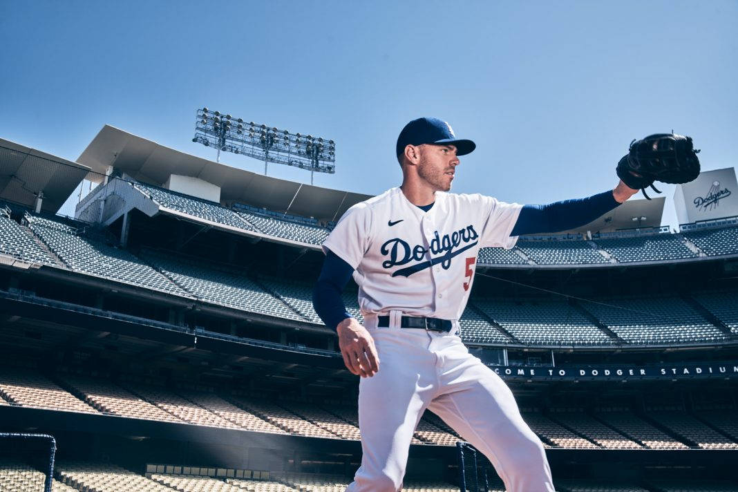 Freddie Freeman 桌布 壁紙 — 一名身穿白色球衣的道奇隊棒球選手，在晴朗藍天下空無一人的球場中蓄勢待發。