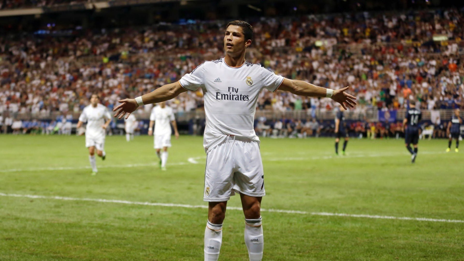 Cr7 桌布 壁紙 — 一名身穿白色皇家馬德里球衣的足球運動員在燈光明亮的球場上張開雙臂站立，背景中球迷們在歡呼。