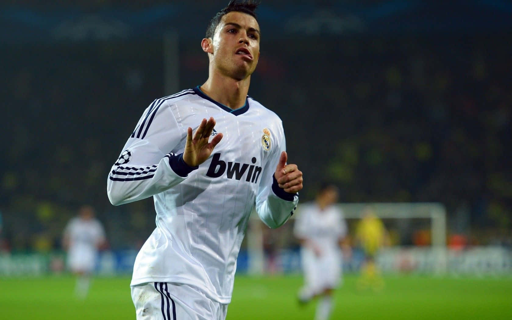 Ronaldo 桌布 壁紙 — 一名身穿白色皇家馬德里球衣的足球員在夜間燈火通明的球場上熱情慶祝。