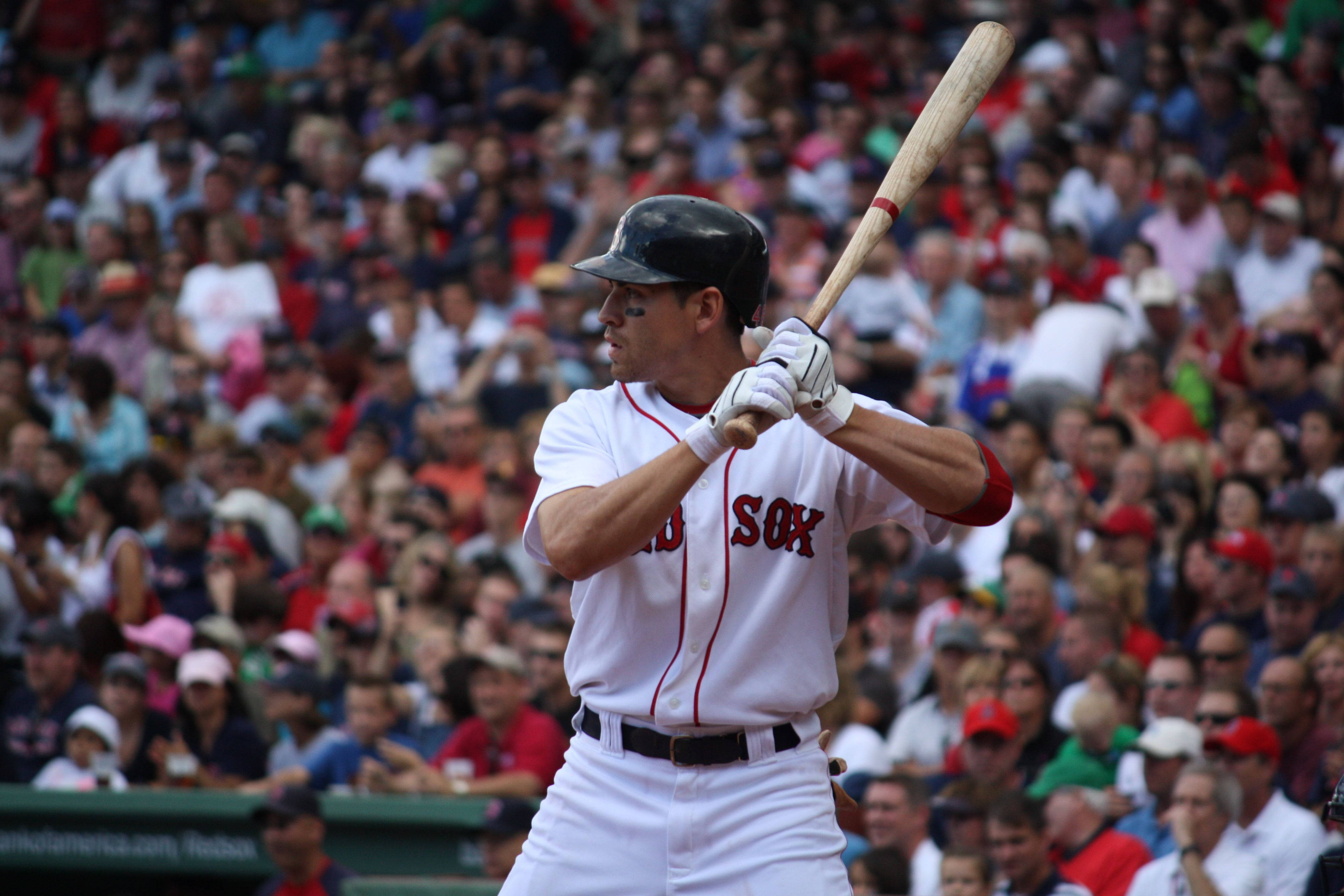 Boston Red Sox 桌布 壁紙 — 一名身穿白色紅襪隊球衣的棒球選手，在擠滿觀眾的球場前，專注地揮棒。