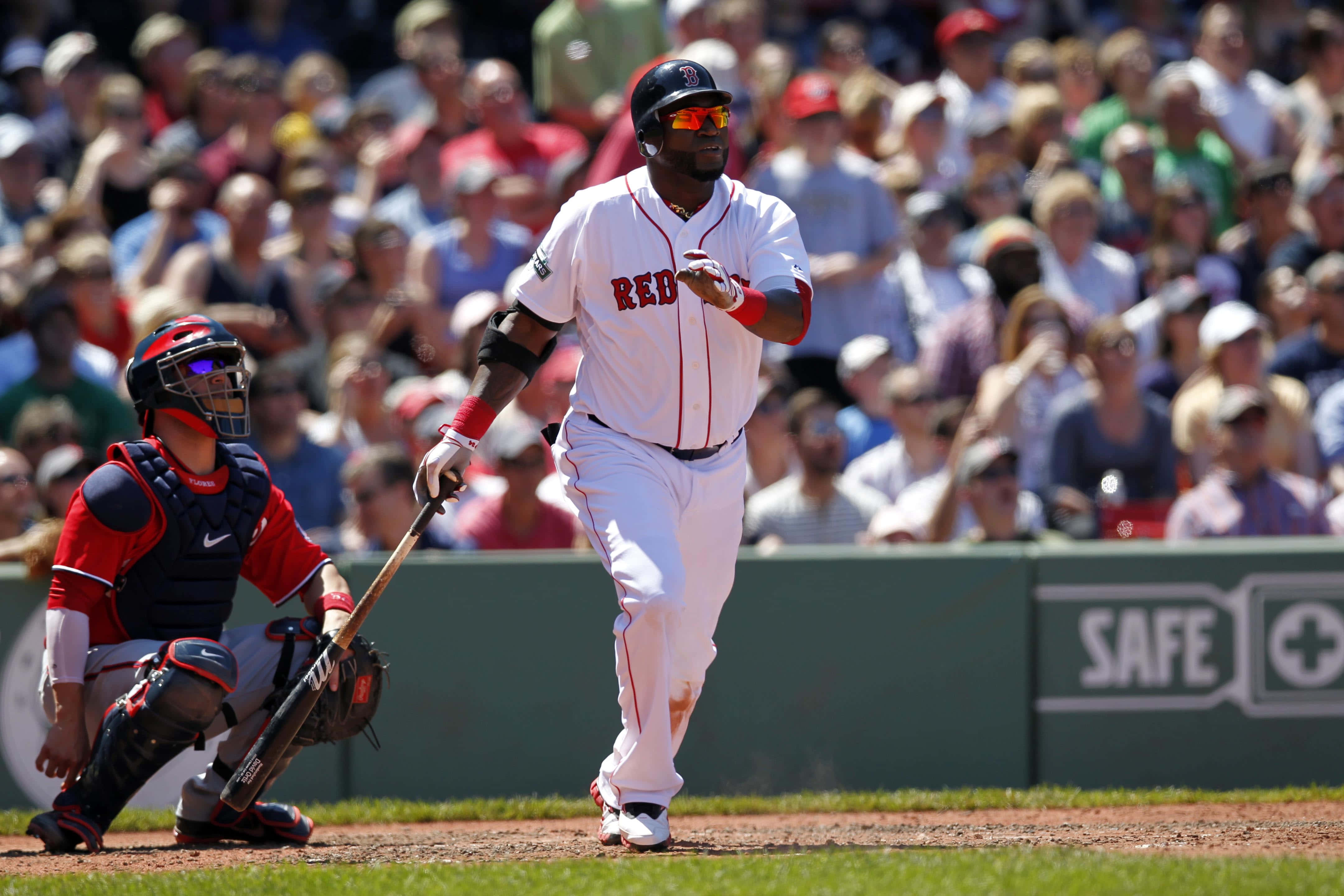 MLB Players 桌布 壁紙 — 一名身穿白色紅襪隊球衣的棒球選手在擊球後跑向一壘，一名身穿紅色裝備的捕手蹲在他身後。