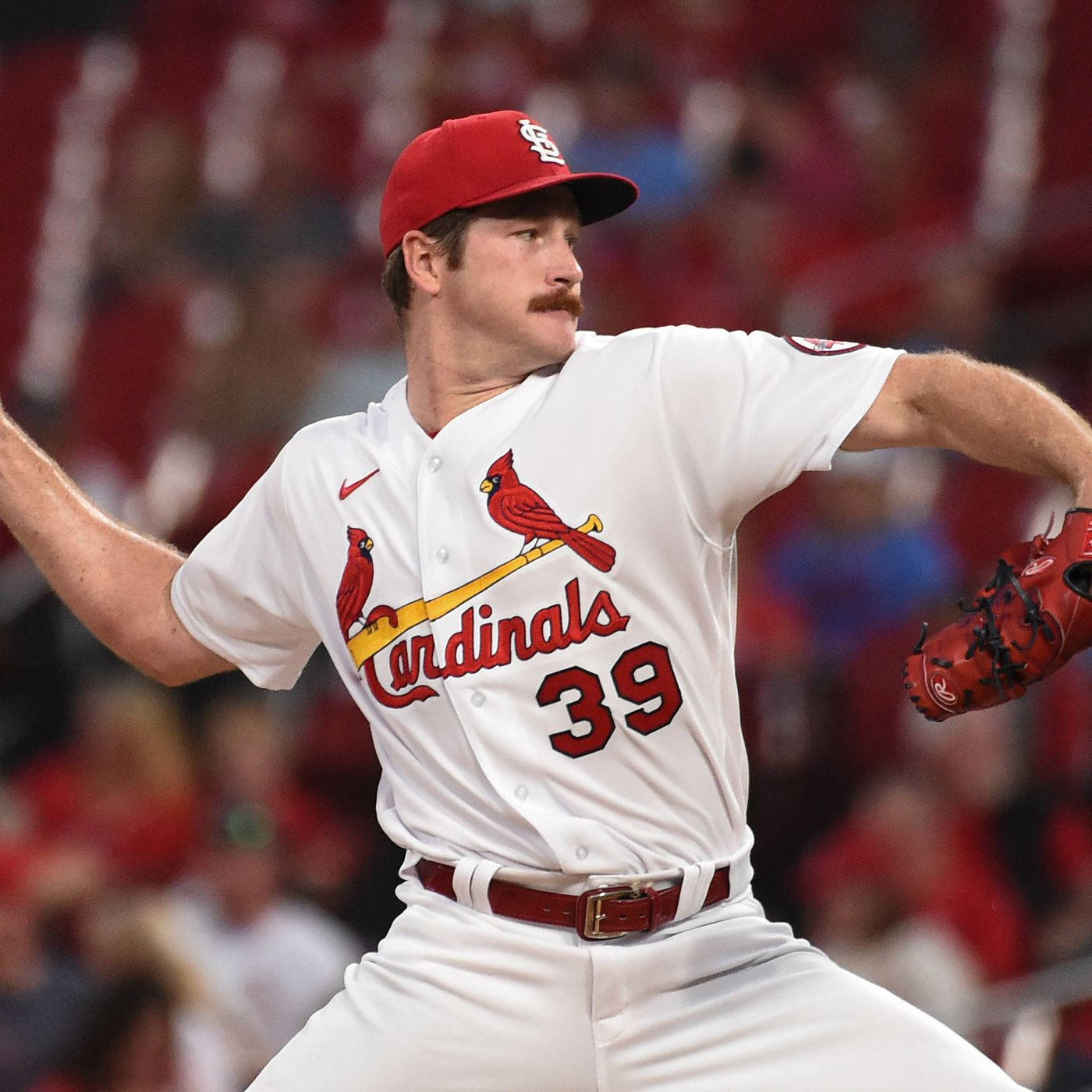 St Louis Cardinals 桌布 壁紙 — 一名身穿白色紅雀隊球衣（帶紅色點綴）的棒球投手，在夜間比賽中於球場燈光下投球。
