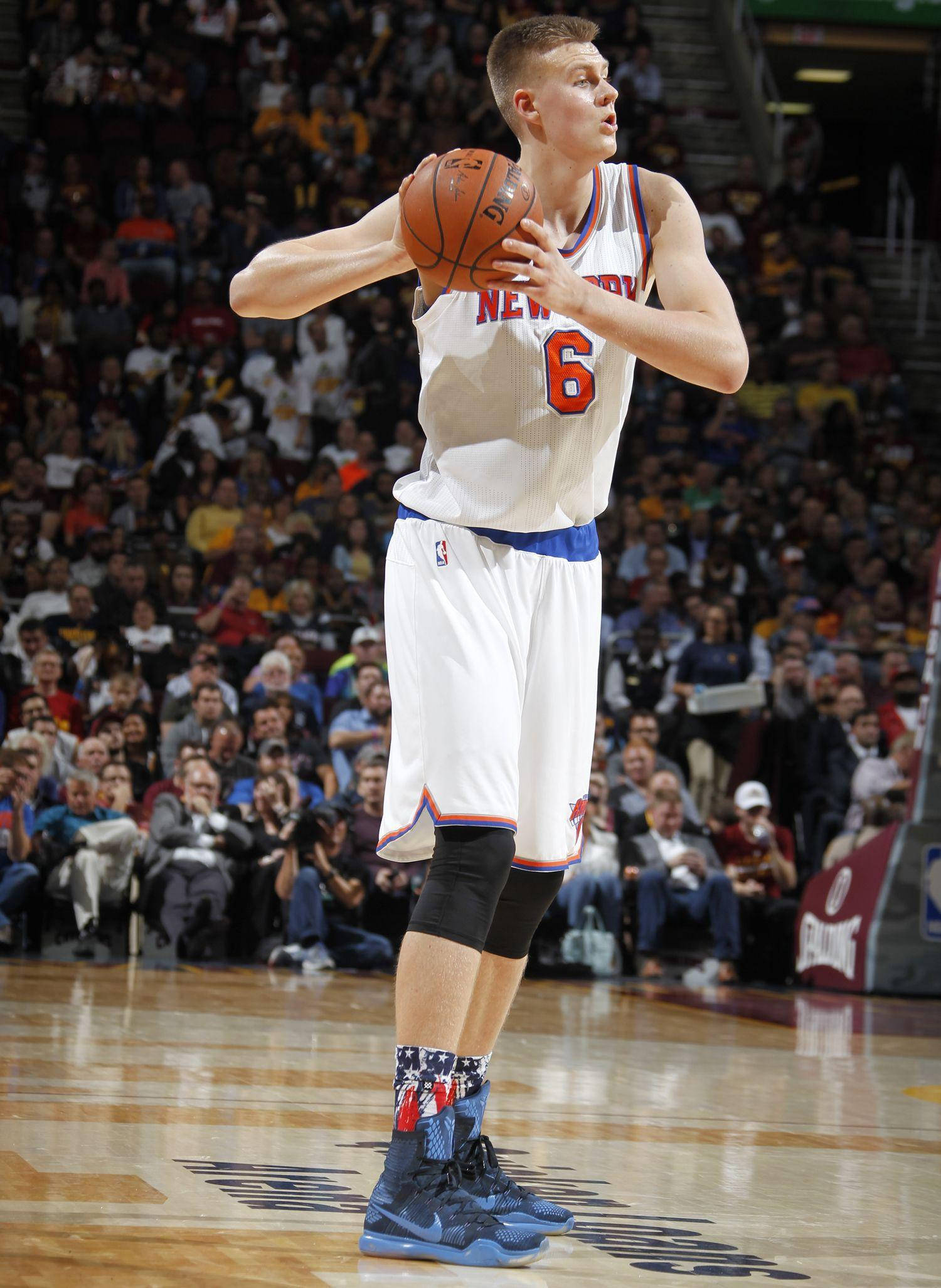Kristaps Porzingis 桌布 壁紙 — 一名身穿白色紐約尼克隊球衣、背號6的籃球運動員在座無虛席的球場準備罰球。