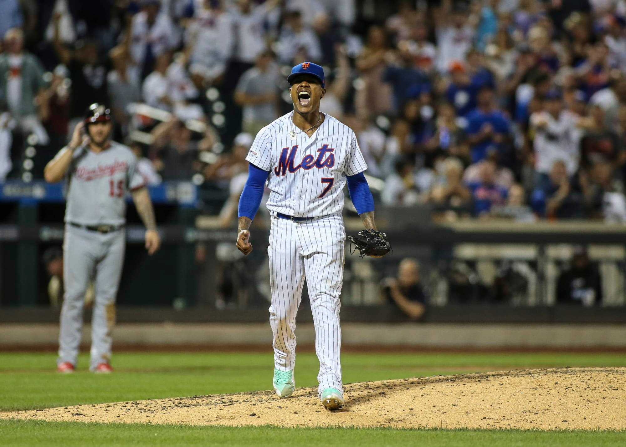 Marcus Stroman 桌布 壁紙 — 一名身穿白色細條紋球衣的Mets棒球選手在球場燈光下於投手丘上發出勝利的咆哮。