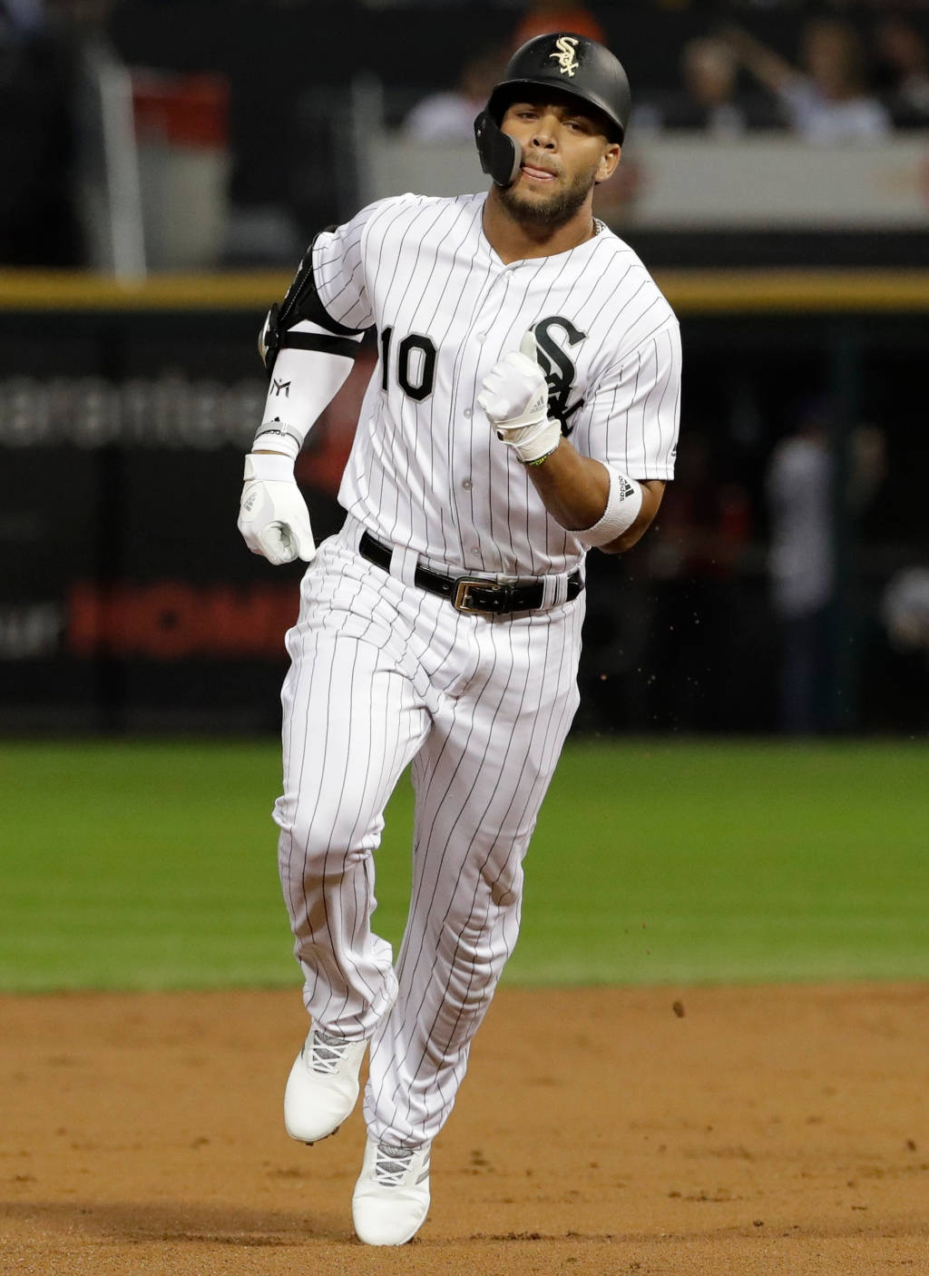 Chicago White Sox 桌布 壁紙 — 一名身穿白色細條紋球衣的棒球運動員在球場燈光下於泥地上衝刺。