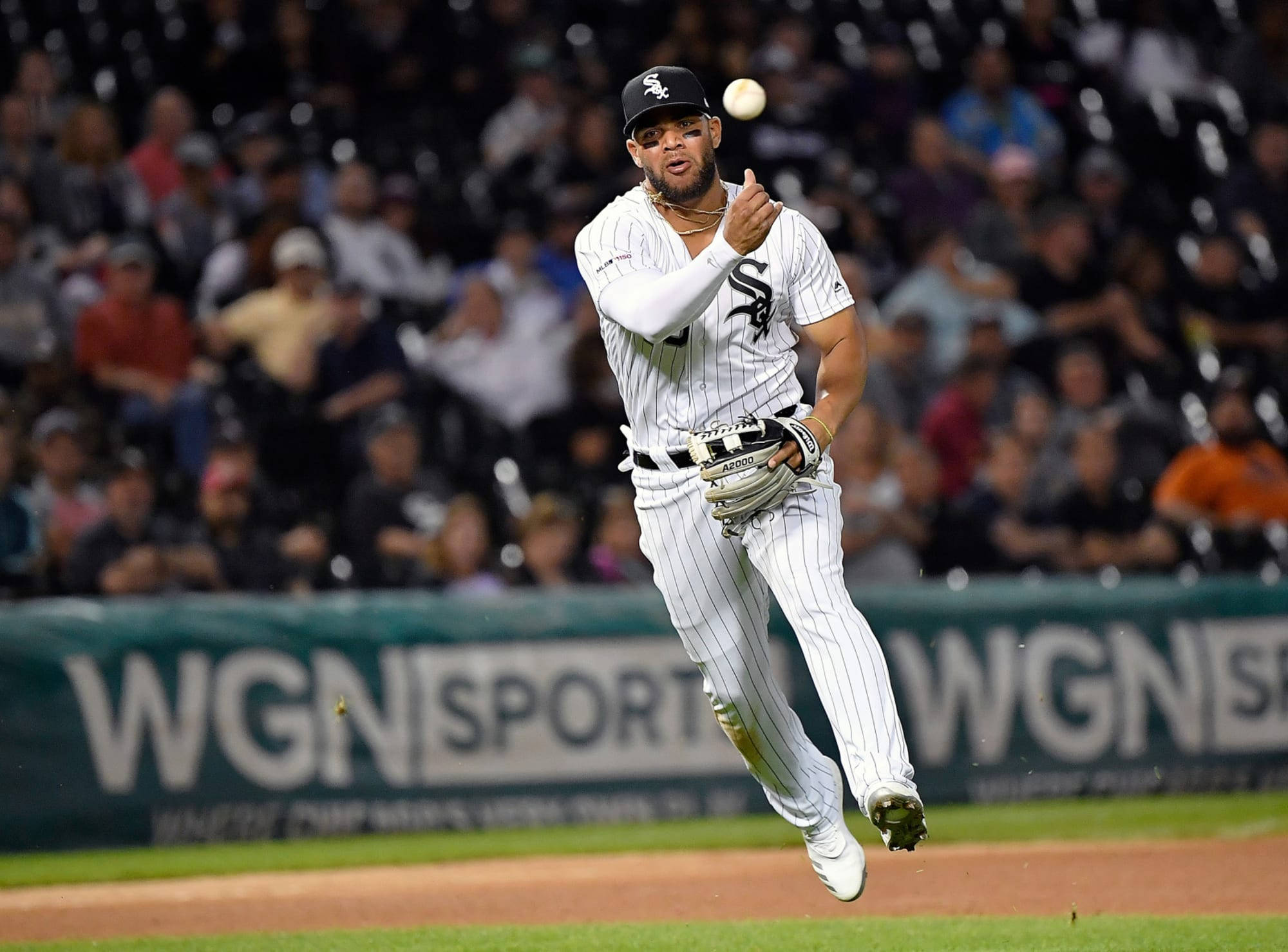 Chicago White Sox 桌布 壁紙 — 一名身穿白色細條紋球衣的棒球選手在夜間比賽中，於球場燈光下躍起接球。