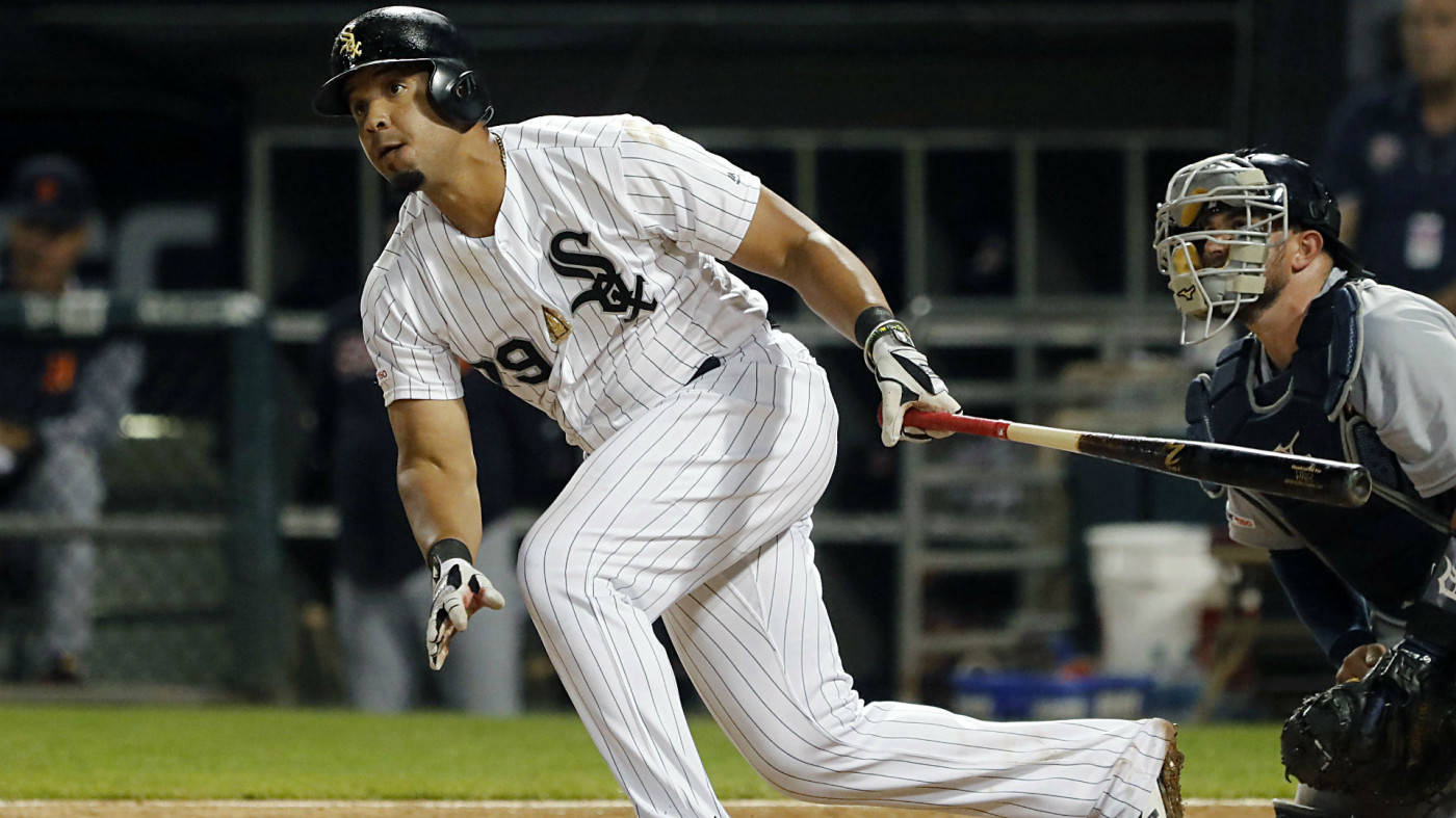 jose abreu 桌布 壁紙 — 一名身穿白色細條紋球衣的棒球選手在夜間比賽中，在捕手蹲在他身後的情況下，專注地揮棒。