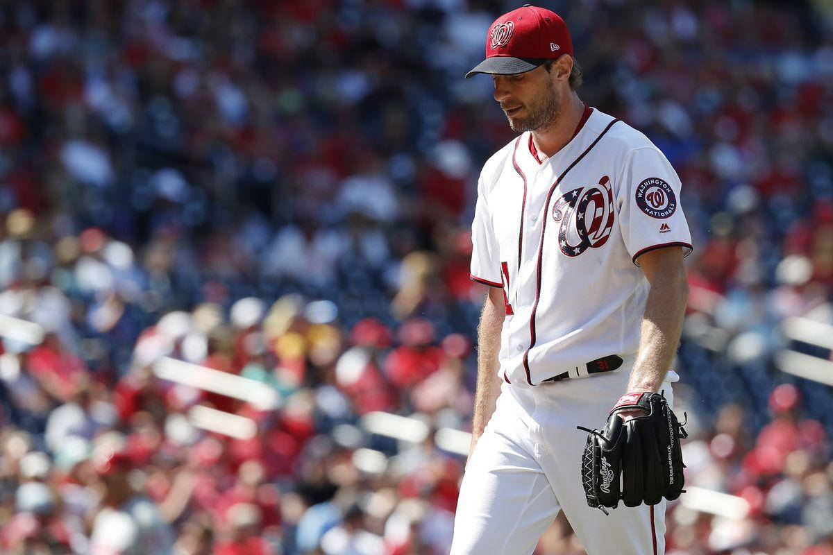 Max Scherzer 桌布 壁紙 — 一名身穿白色華盛頓國民隊球衣的棒球投手，在明亮的日光下手戴手套離開球場。