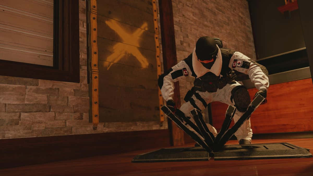 Rainbow Six Siege Rook 桌布 壁紙 — 一名身穿白色裝備的戰術操作員在光線昏暗的木製房間內低蹲，房間有磚牆和一扇門上發光的黃色X。
