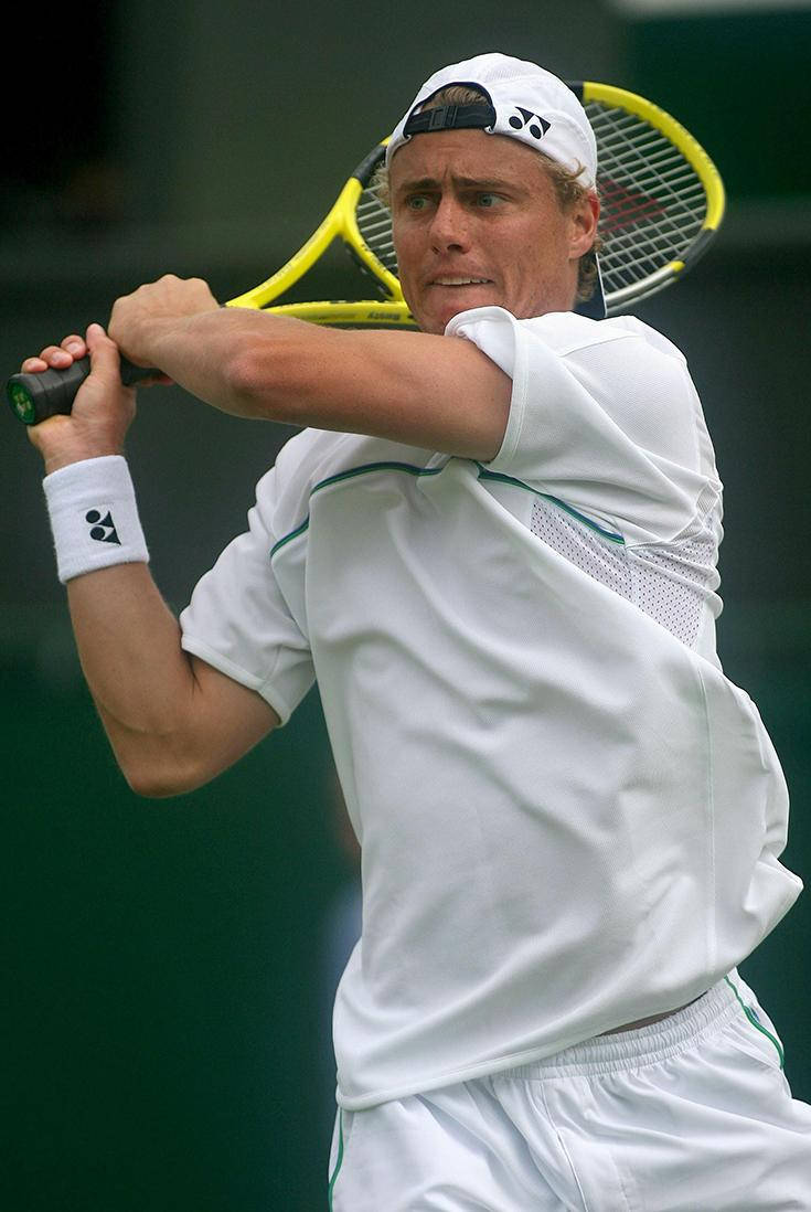 Australian Open 桌布 壁紙 — 一名身穿白色裝備的男性網球選手，在綠色背景下專注地揮動黃色球拍。