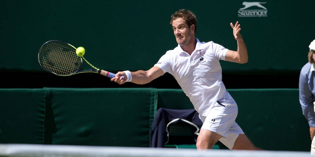 Tennis 桌布 壁紙 — 一名身穿白色裝備的男網球選手在綠色背景下揮拍擊打一個亮黃色的球。