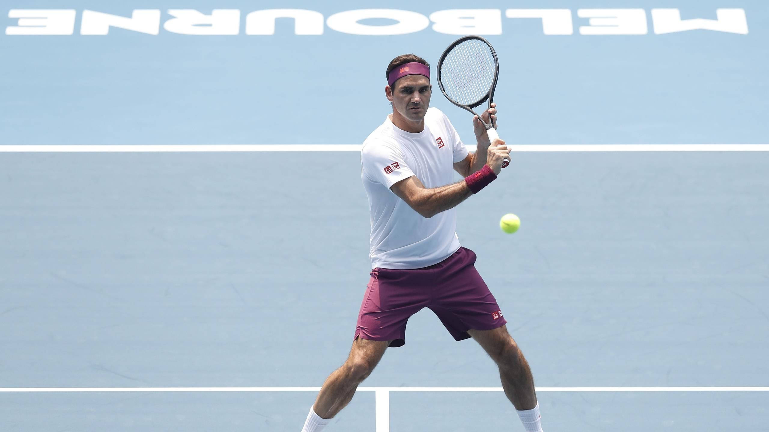 Australian Open 桌布 壁紙 — 一名身穿白色襯衫和栗色短褲的男性網球選手在藍色硬地球場上揮拍擊打黃色球，背景可見「MELBOURNE」。