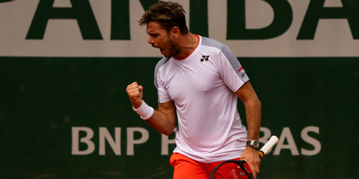 Tennis 桌布 壁紙 — 一名身穿白色襯衫和橙色短褲的男網球運動員在紅土球場上握拳慶祝。