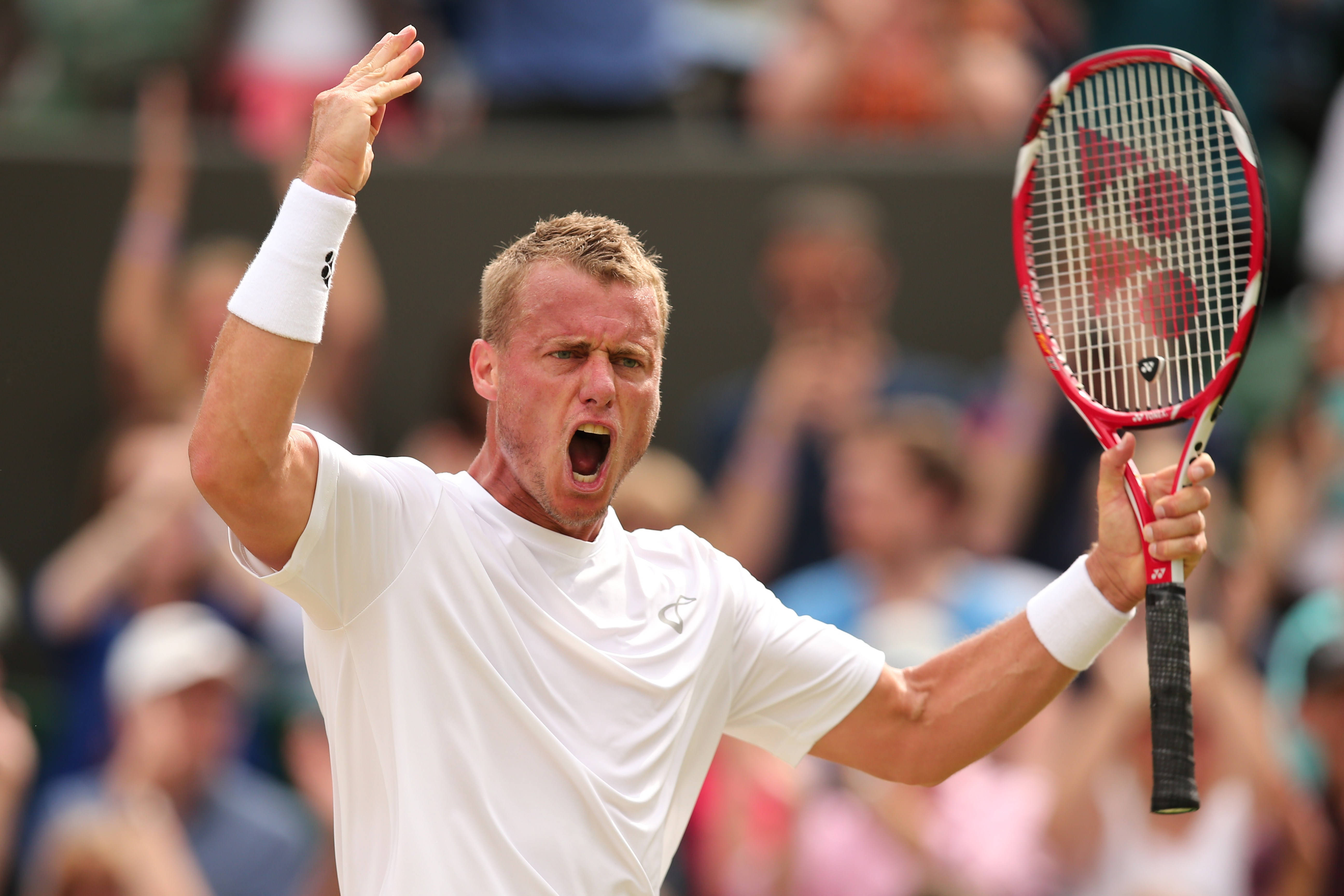 Australian Open 桌布 壁紙 — 一名身穿白色襯衫和護腕的男網球運動員，在陽光照耀的球場上，一手握著紅色球拍，另一手高舉，發出勝利的吶喊。