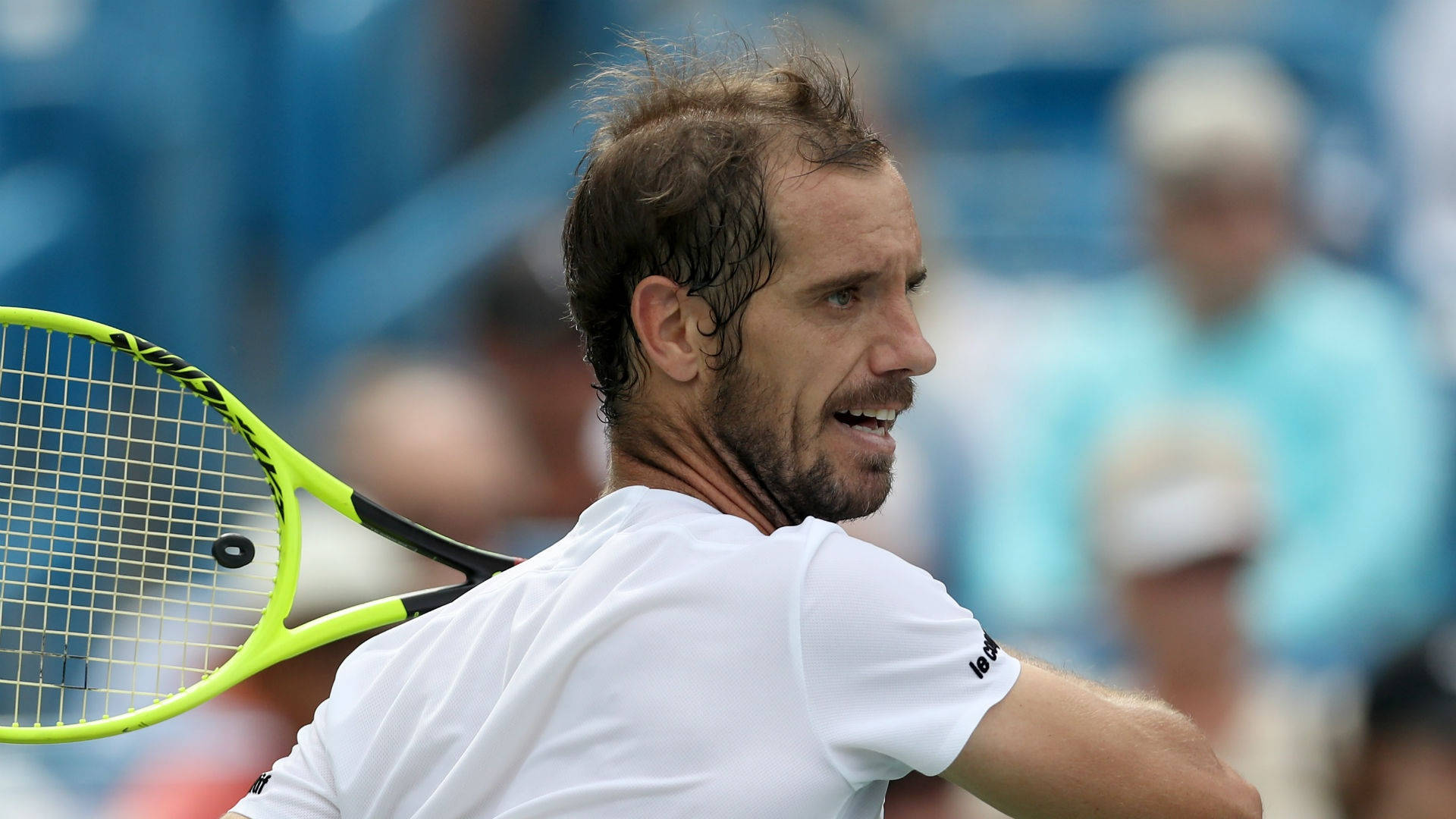 Tennis 桌布 壁紙 — 一名身穿白色襯衫的男性網球選手在比賽中專注地揮動螢光黃色球拍。