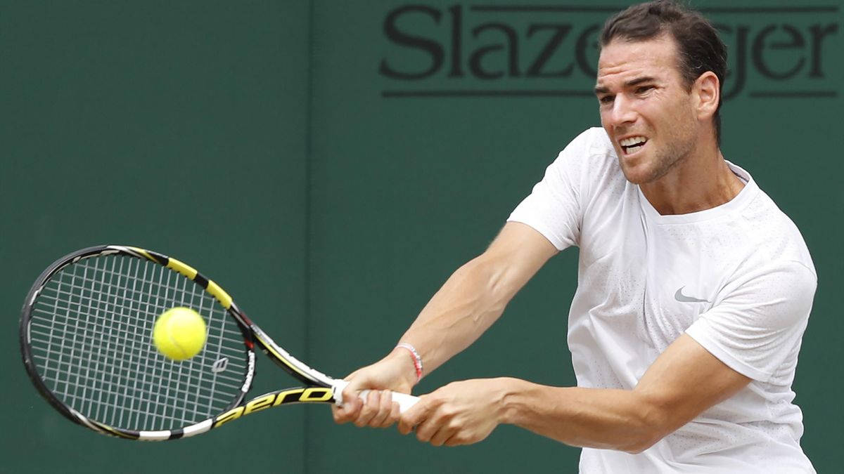 Tennis 桌布 壁紙 — 一名身穿白色襯衫的男網球選手揮動球拍，將黃色球擊向綠色牆壁。