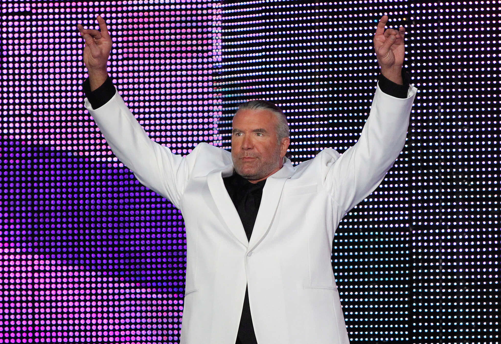 WWE Desktop 桌布 壁紙 — 一名身穿白色西裝的男子，在充滿活力的紫色和藍色LED點陣背景前，勝利地舉起雙臂。