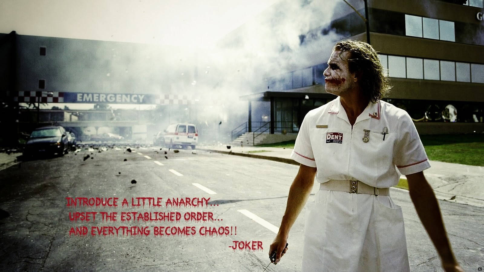 Heath Ledger Joker 桌布 壁紙 — 一名身穿白色護士制服、化妝弄髒的男子站在冒煙的醫院急診入口前，並有文字覆蓋。