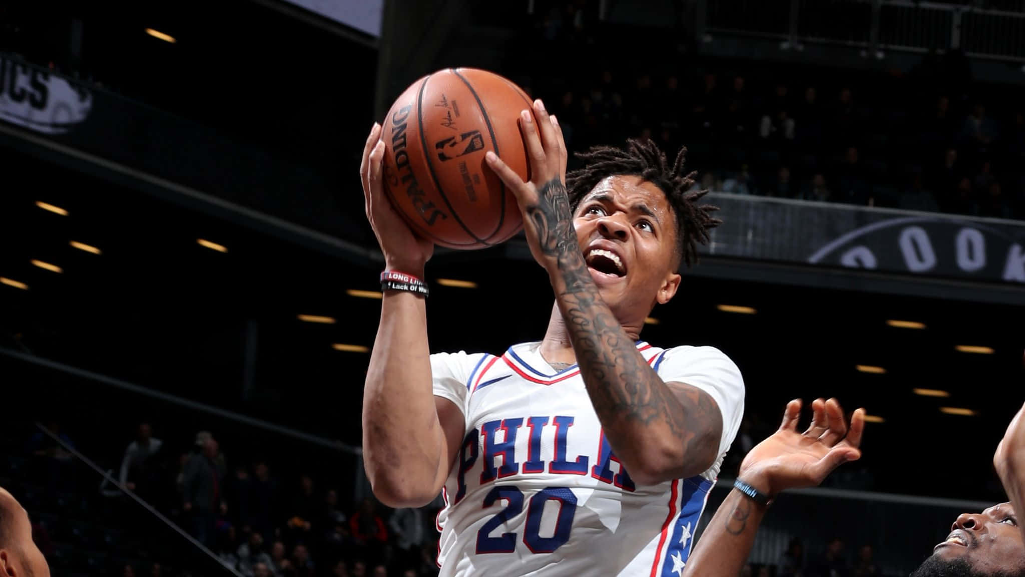 NBA 桌布 壁紙 — 一名身穿白色費城球衣的籃球運動員在場館燈光下專注地跳起投籃。