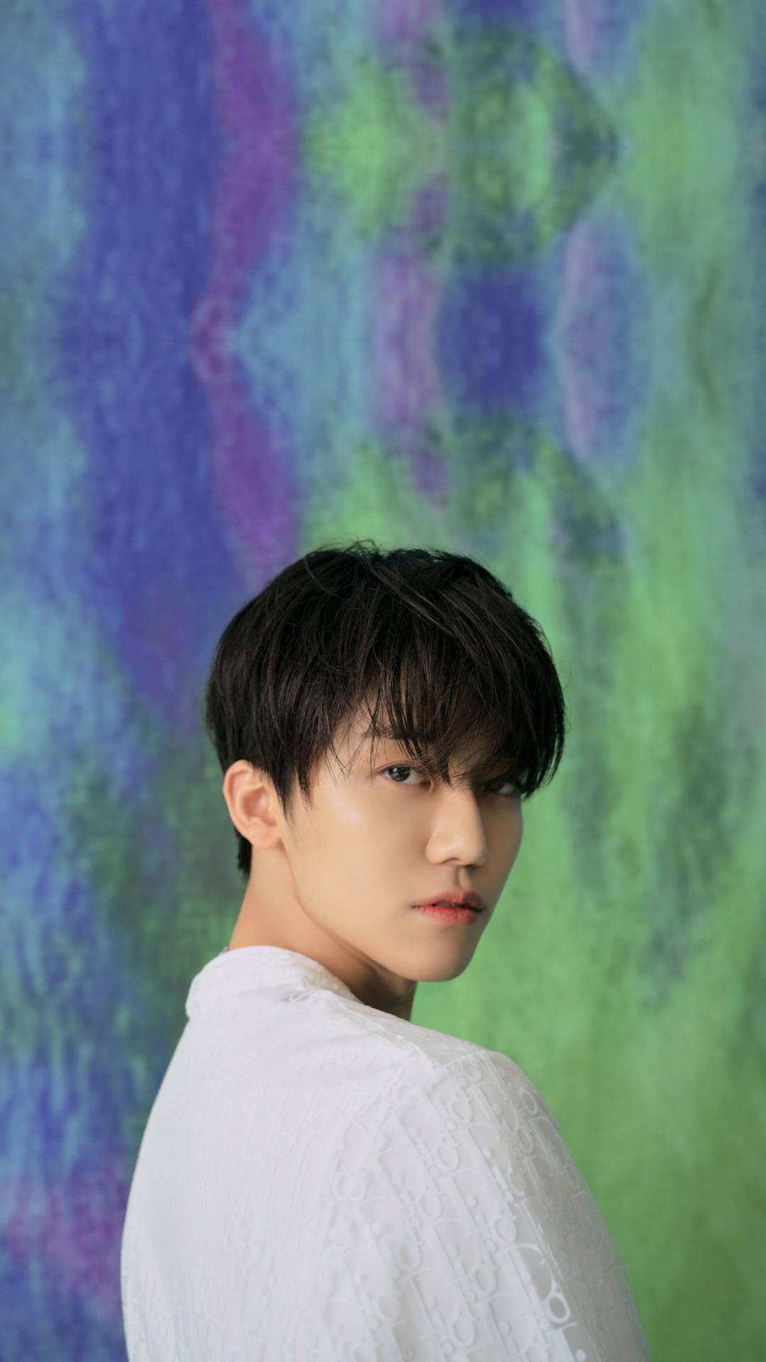 jaemin 桌布 壁紙 — 一名身穿白色質感襯衫的年輕男子，在充滿活力的藍色、紫色和綠色漩渦抽象背景上轉頭。