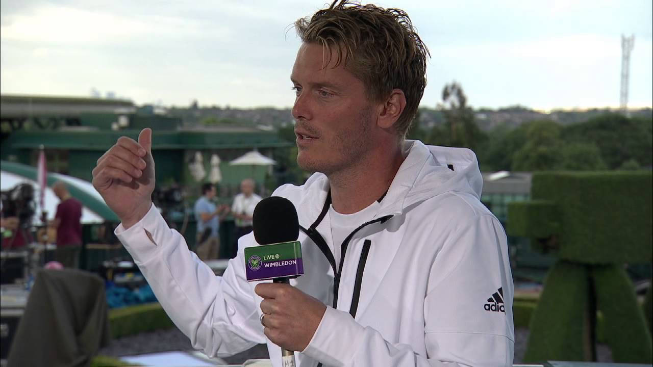 Tennis 桌布 壁紙 — 一名身穿白色連帽衫的男網球選手在戶外記者會上，一邊對著溫布頓麥克風說話一邊做手勢。