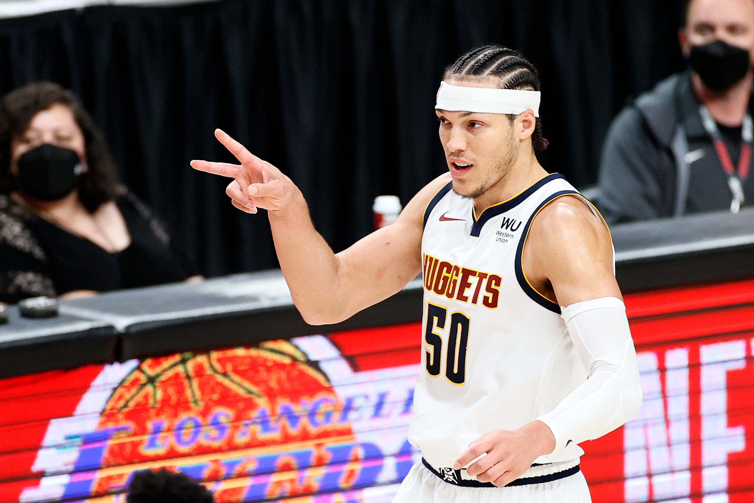 aaron gordon 桌布 壁紙 — 一名身穿白色金塊隊50號球衣的籃球運動員在比賽中做出和平手勢，背景有觀眾。